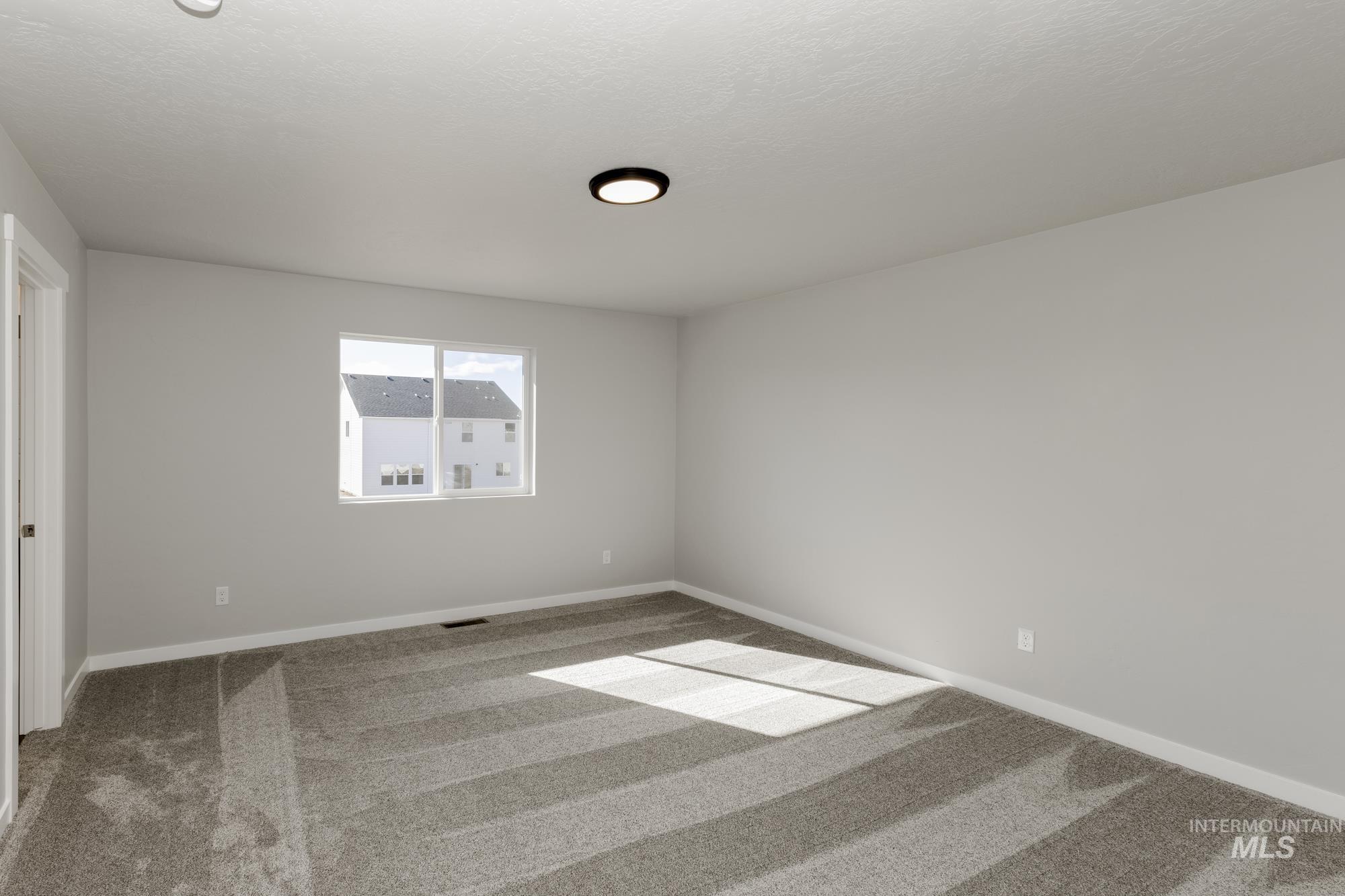 Carpeted spare room with baseboards