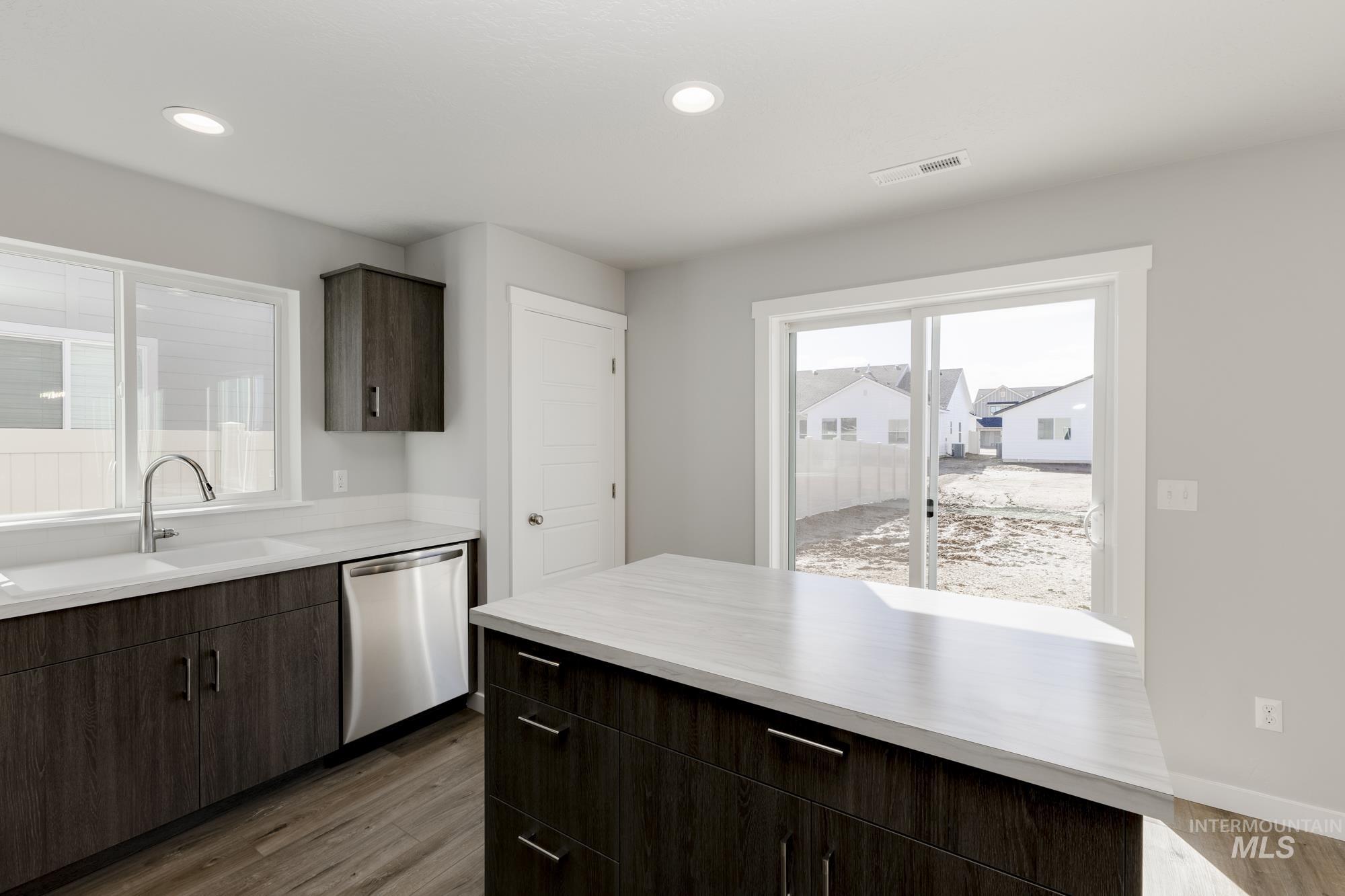 Kitchen featuring dark brown cabinets, dark wood-type flooring, stainless steel dishwasher, recessed lighting, and modern cabinets