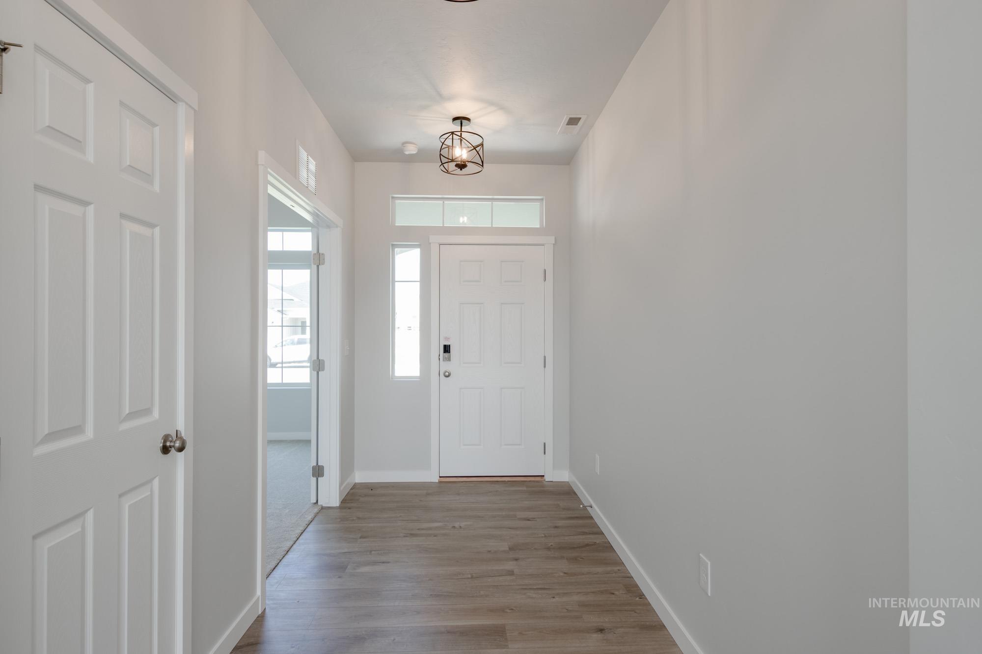 Foyer entrance featuring wood finished floors and a chandelier