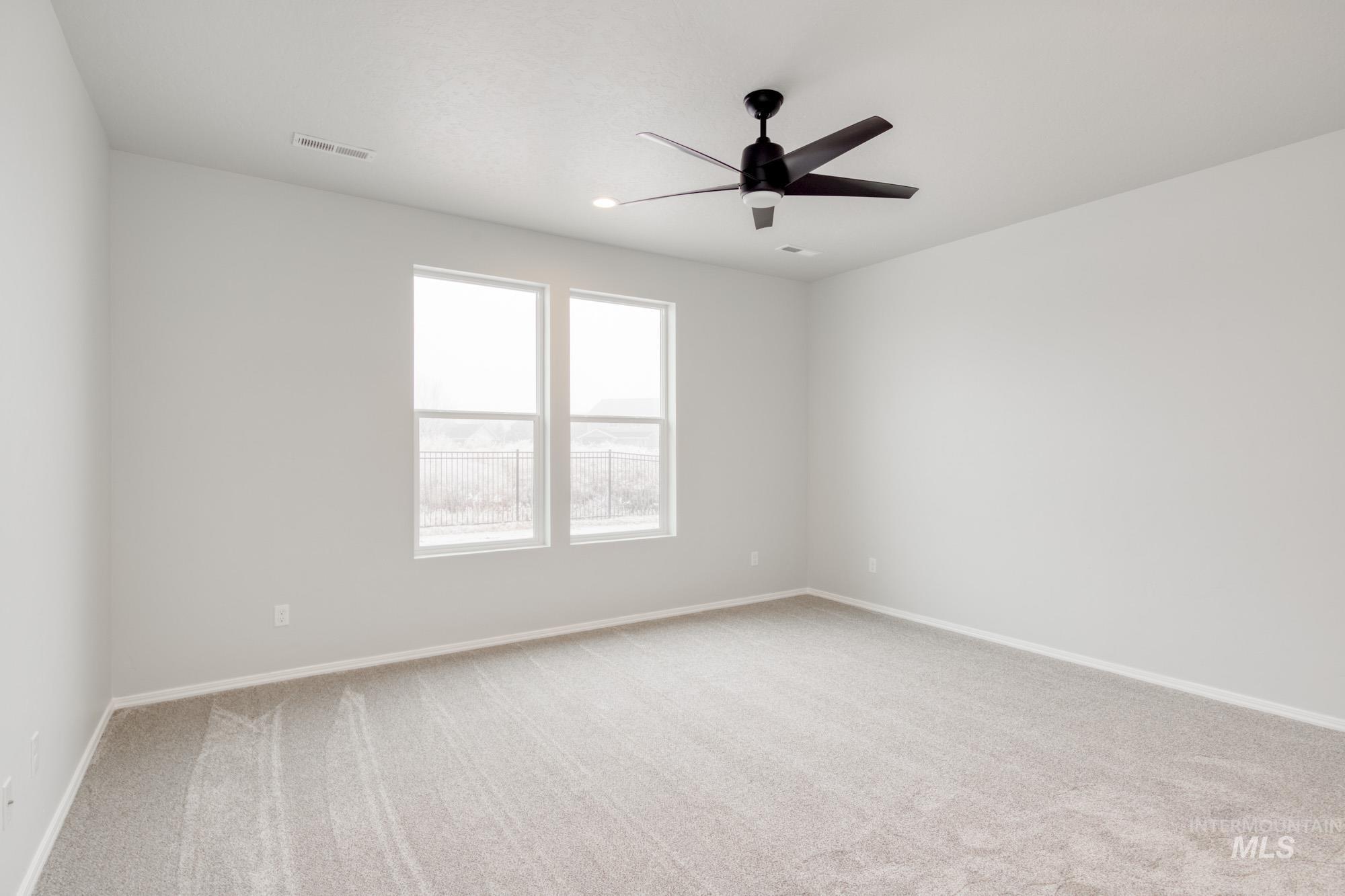 Empty room with light colored carpet, ceiling fan, and recessed lighting