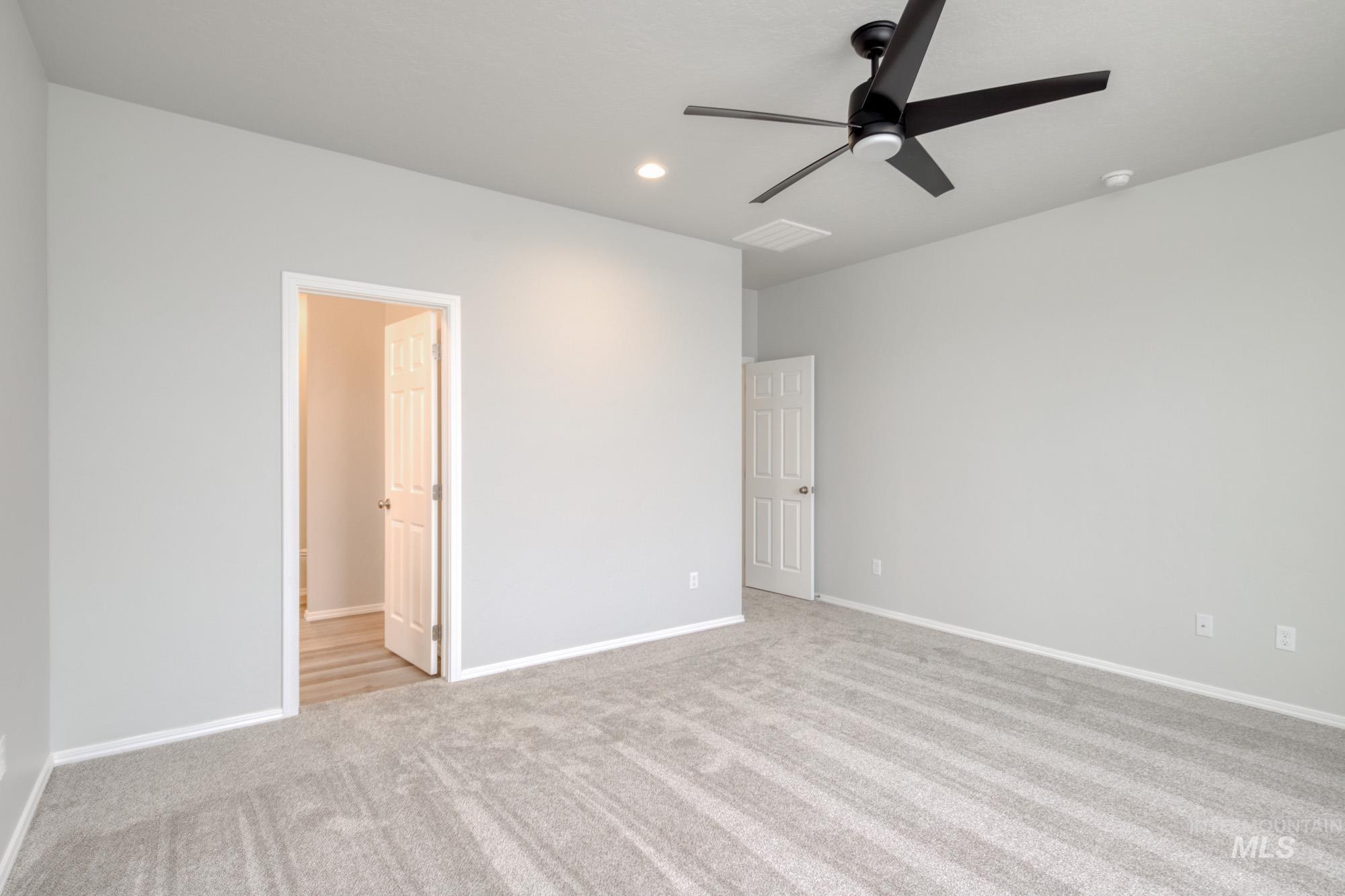 Unfurnished bedroom featuring light carpet, ceiling fan, and recessed lighting