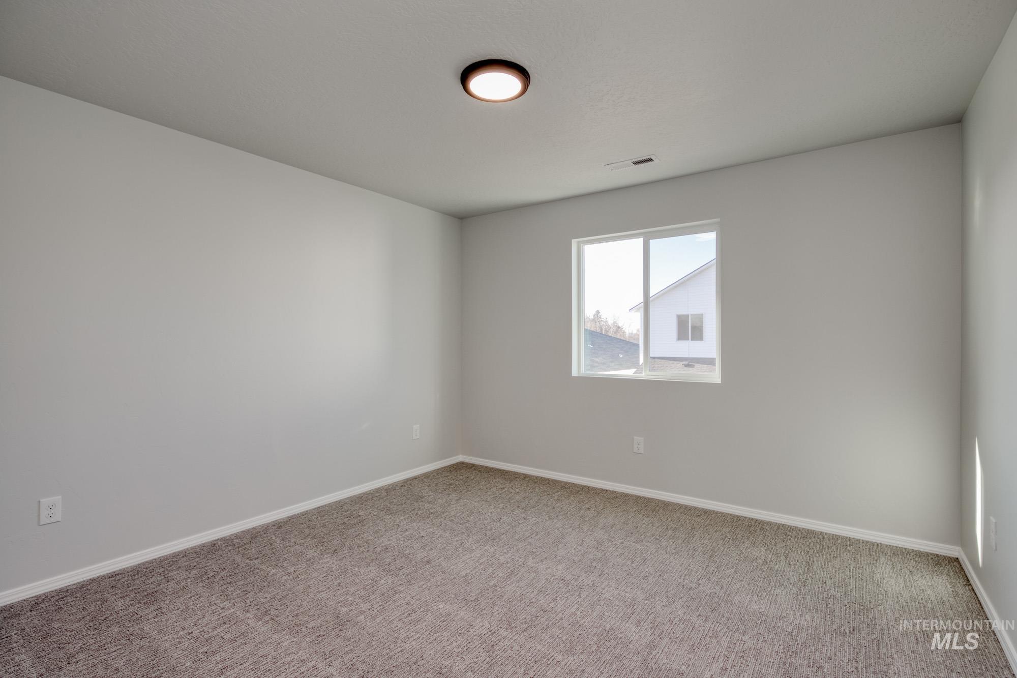 Carpeted empty room featuring baseboards