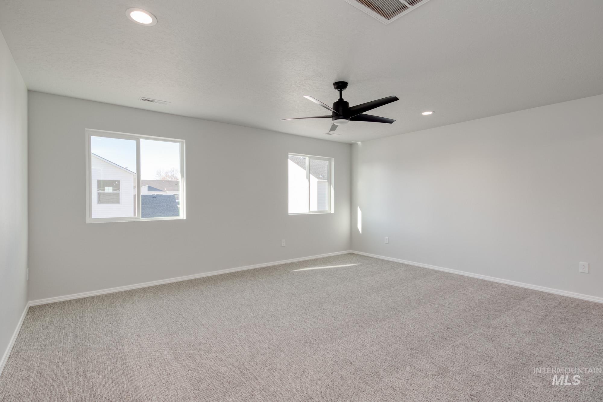 Spare room featuring light colored carpet, recessed lighting, and a ceiling fan