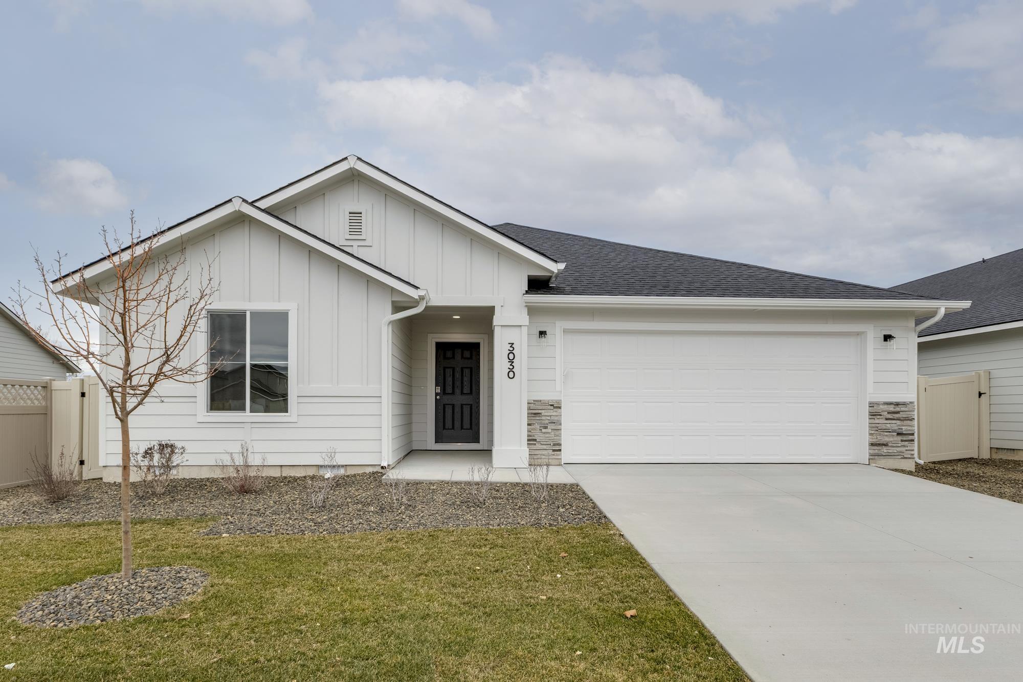 Single story home with board and batten siding, concrete driveway, an attached garage, a shingled roof, and stone siding
