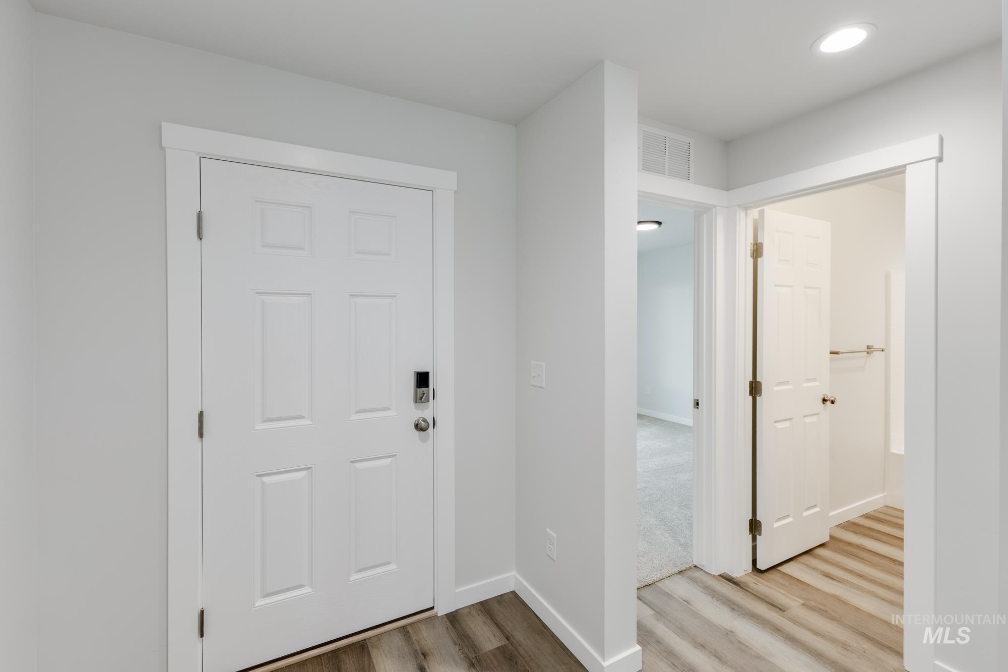 Entryway with light wood-style floors and recessed lighting