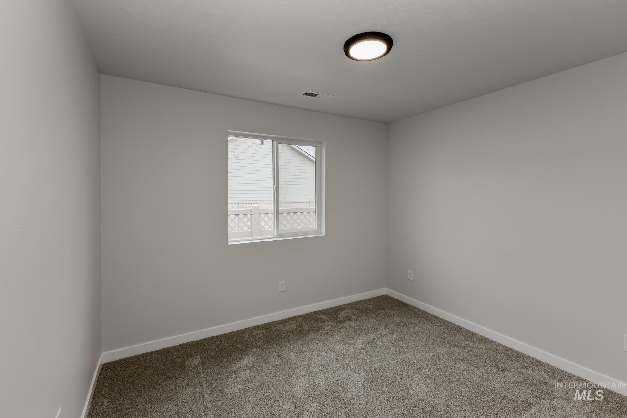 Spare room featuring baseboards and carpet floors