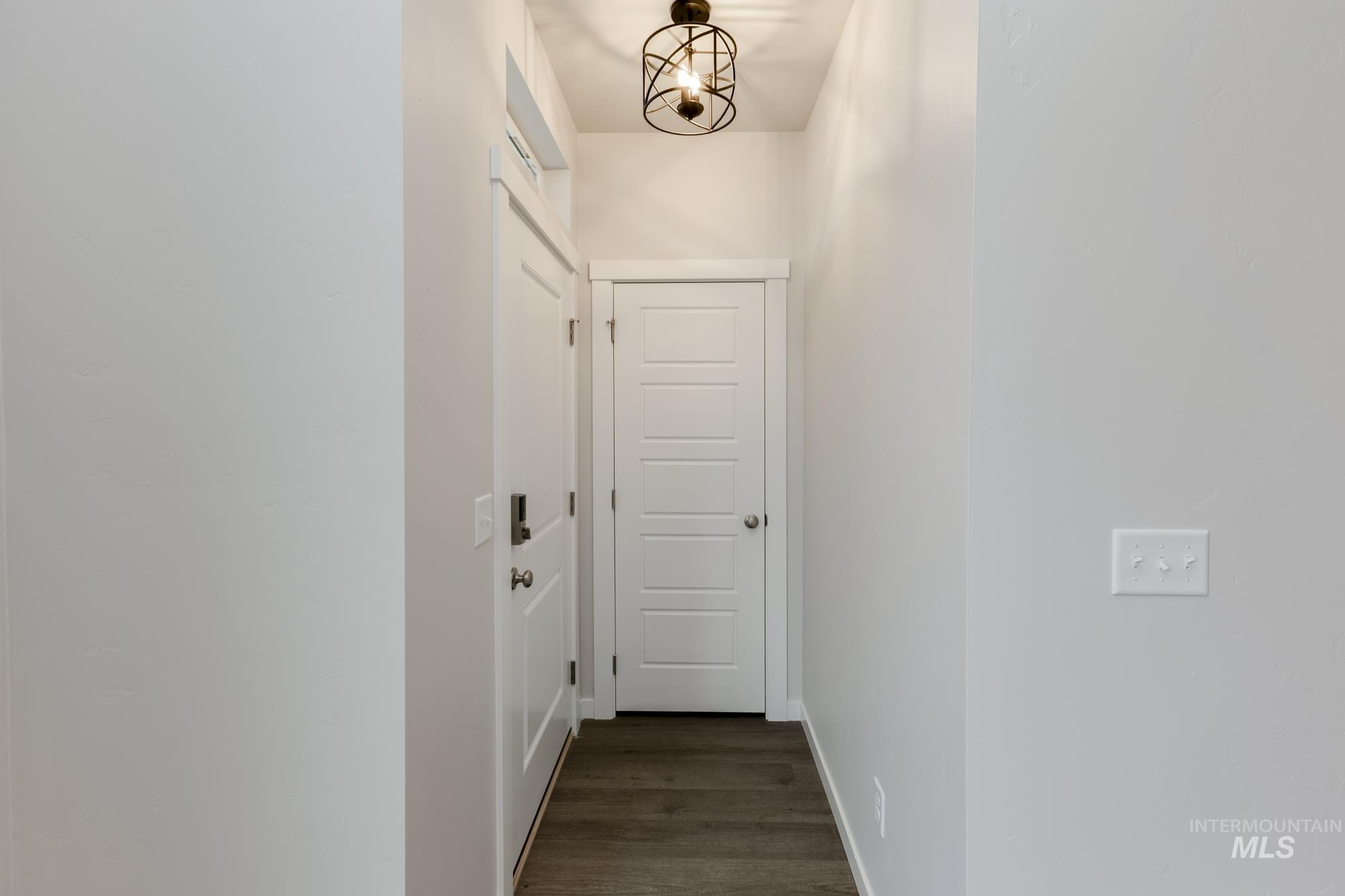 Hall with dark wood-style flooring and baseboards