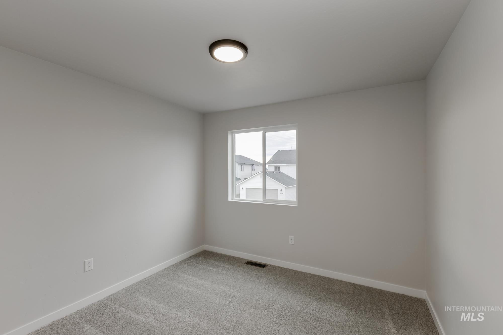 Carpeted empty room featuring baseboards