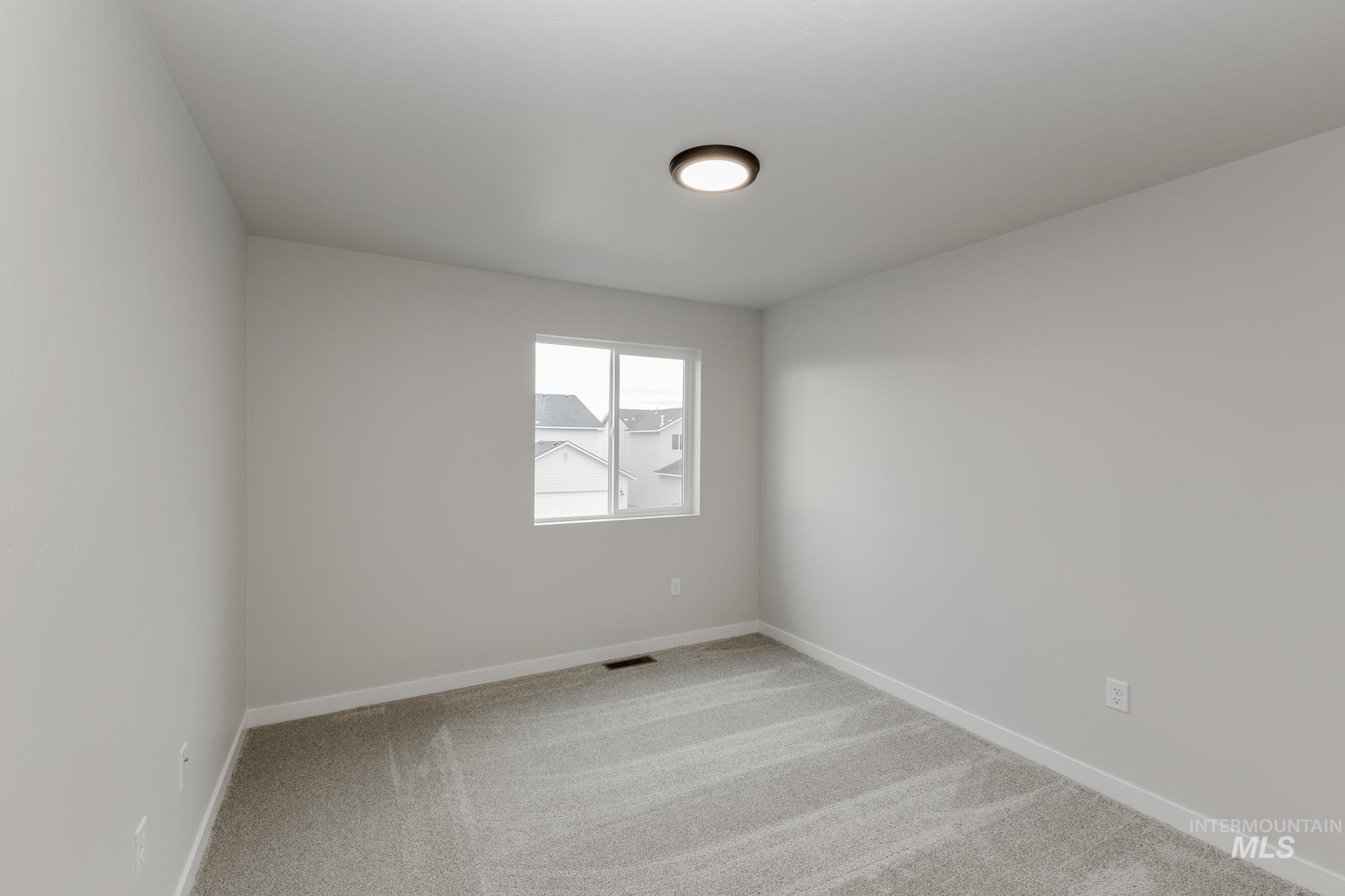 Unfurnished room with light colored carpet and baseboards