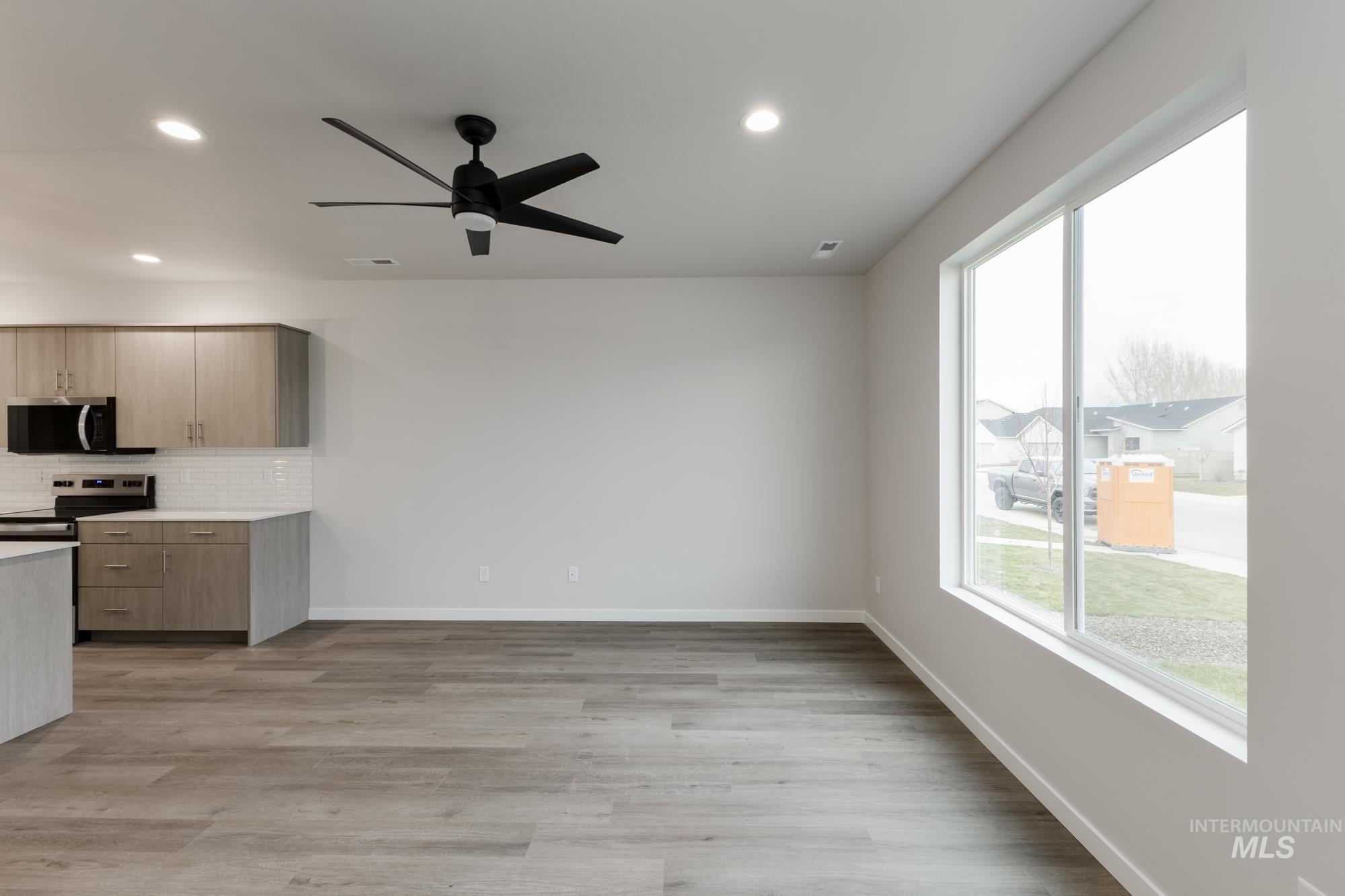 Kitchen featuring backsplash, modern cabinets, light wood-type flooring, recessed lighting, and stainless steel appliances