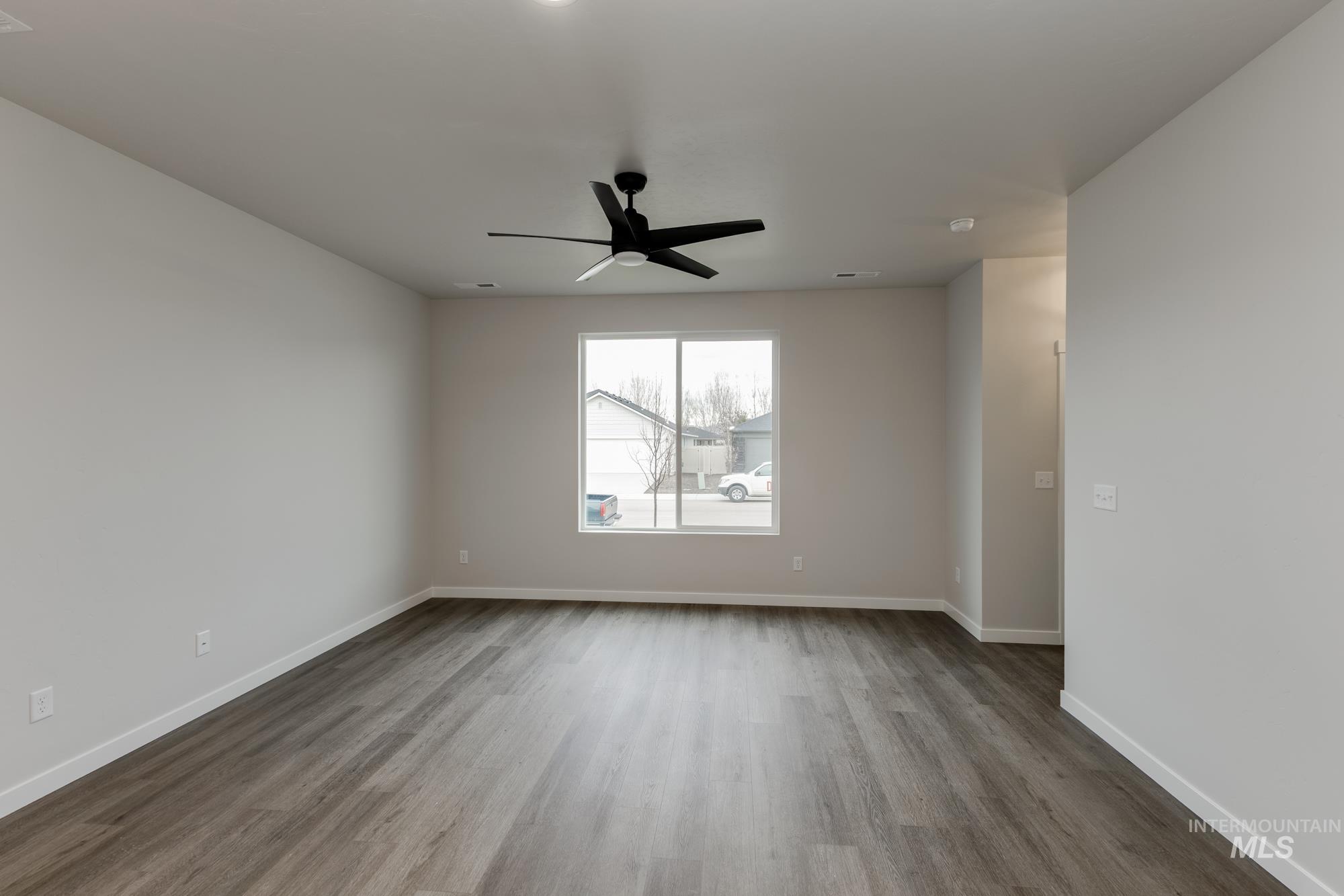 Empty room with light wood finished floors and ceiling fan