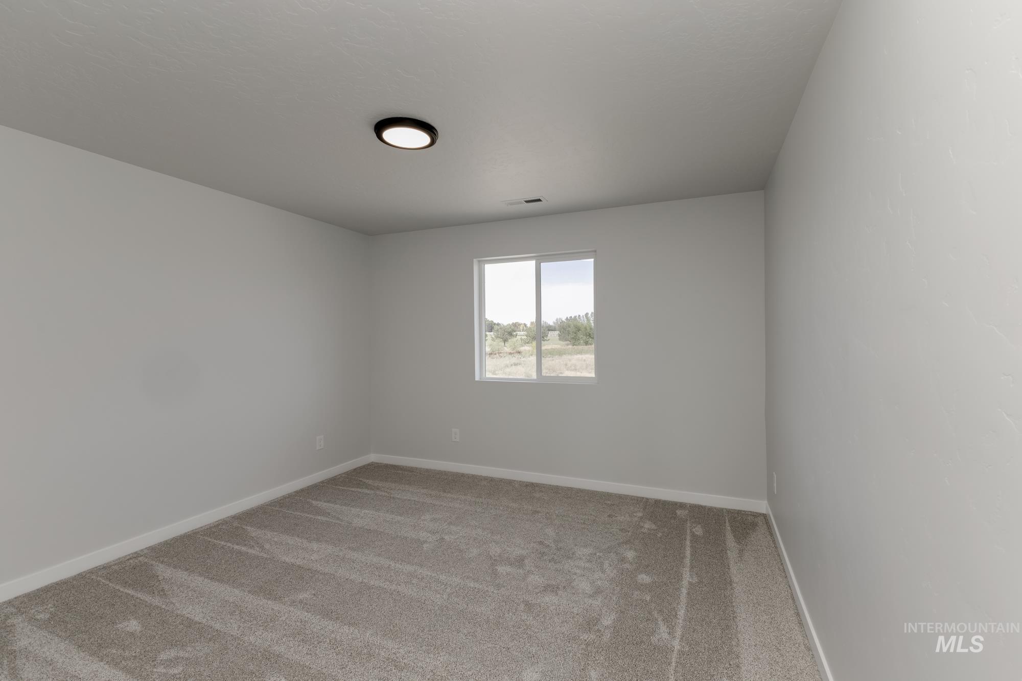 Spare room with light colored carpet and baseboards