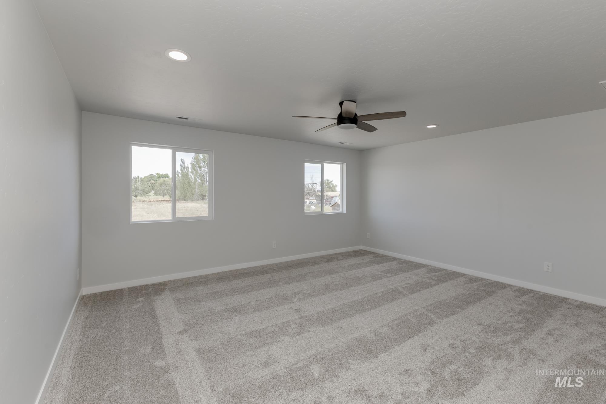 Empty room featuring light colored carpet, recessed lighting, and ceiling fan