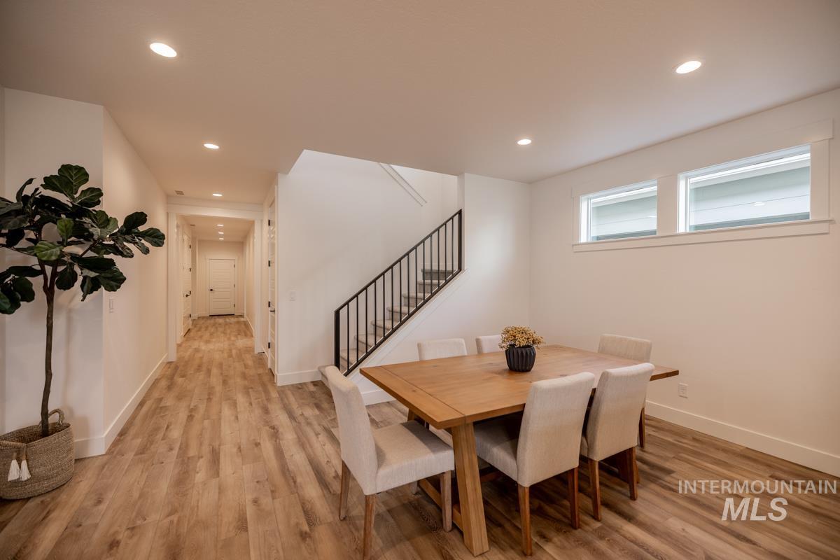 Dining room with light wood-type flooring, stairway, and recessed lighting