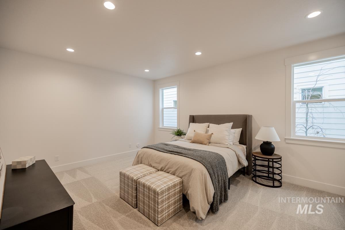 Bedroom with light carpet and recessed lighting