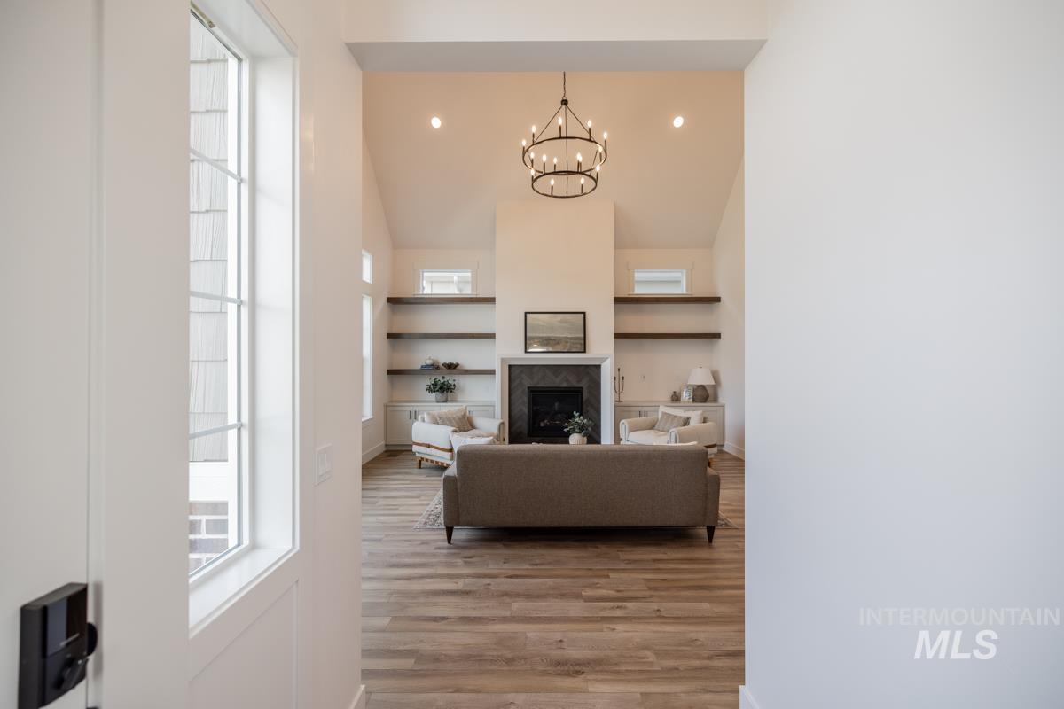 Living area with light wood-style floors, a fireplace, recessed lighting, a chandelier, and built in shelves