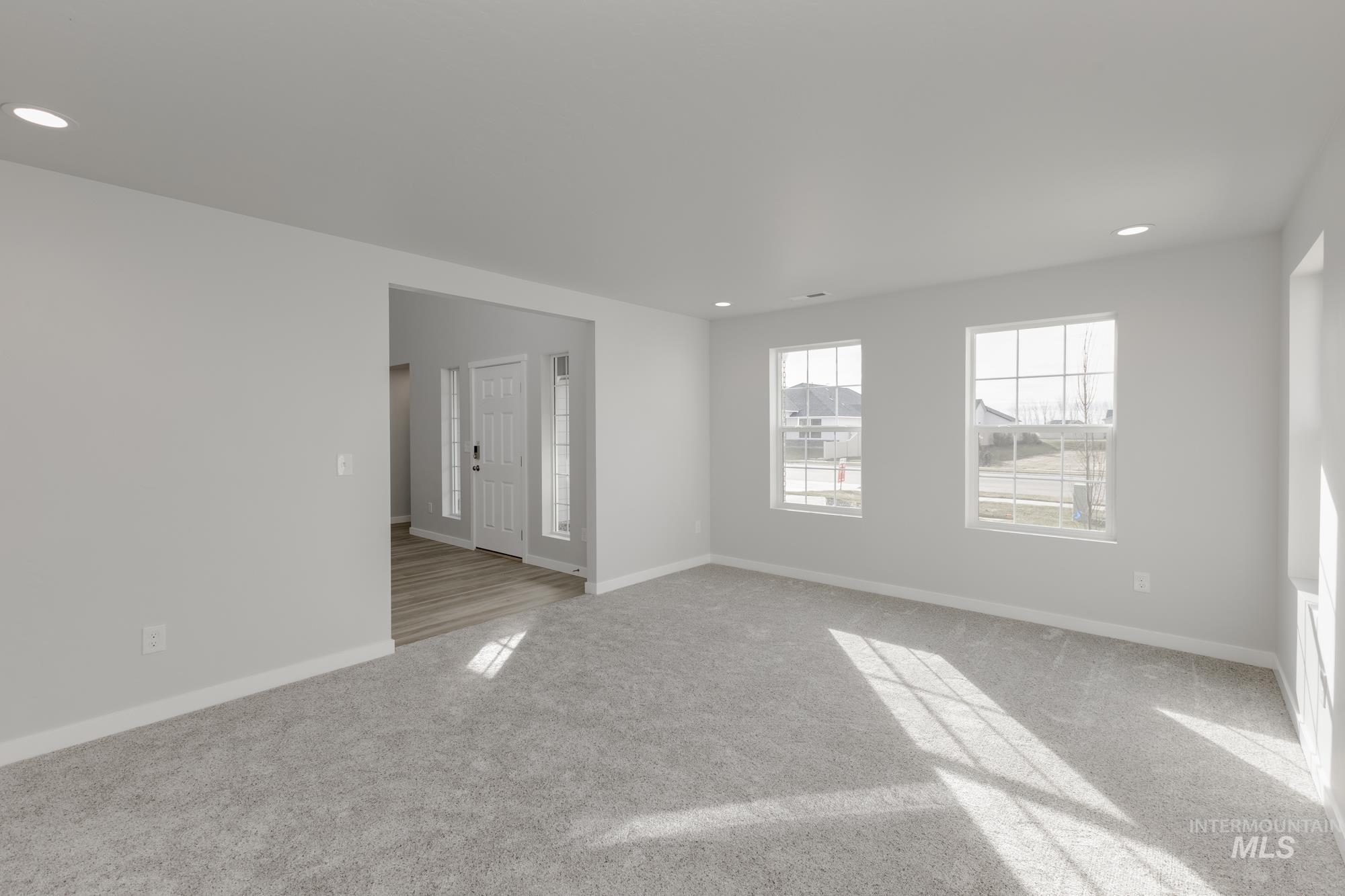 Empty room with recessed lighting and light carpet