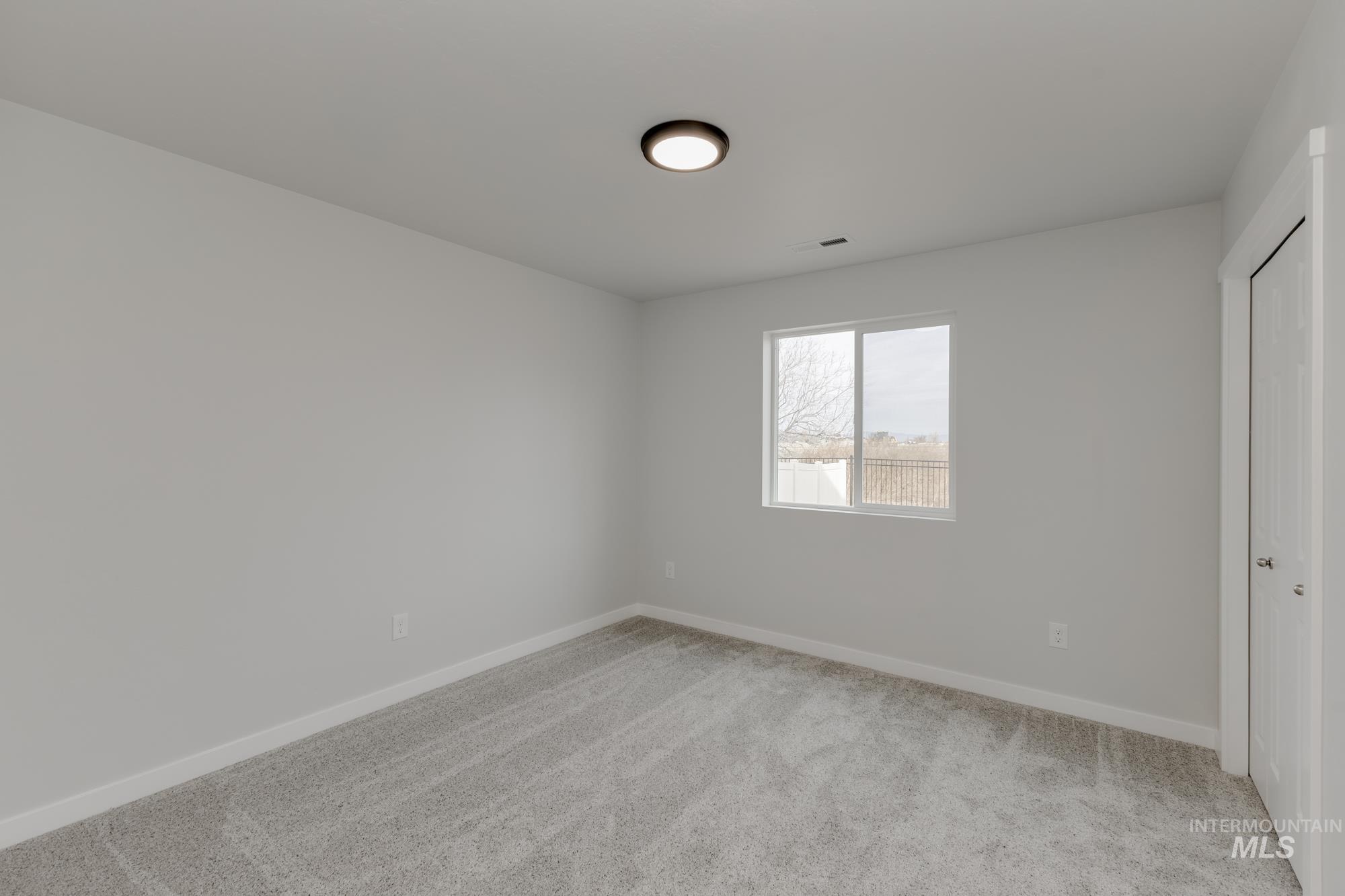 Unfurnished bedroom featuring light colored carpet and a closet