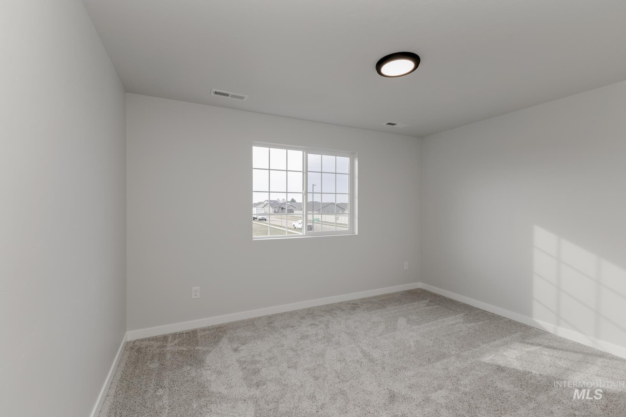 Empty room with light carpet and baseboards