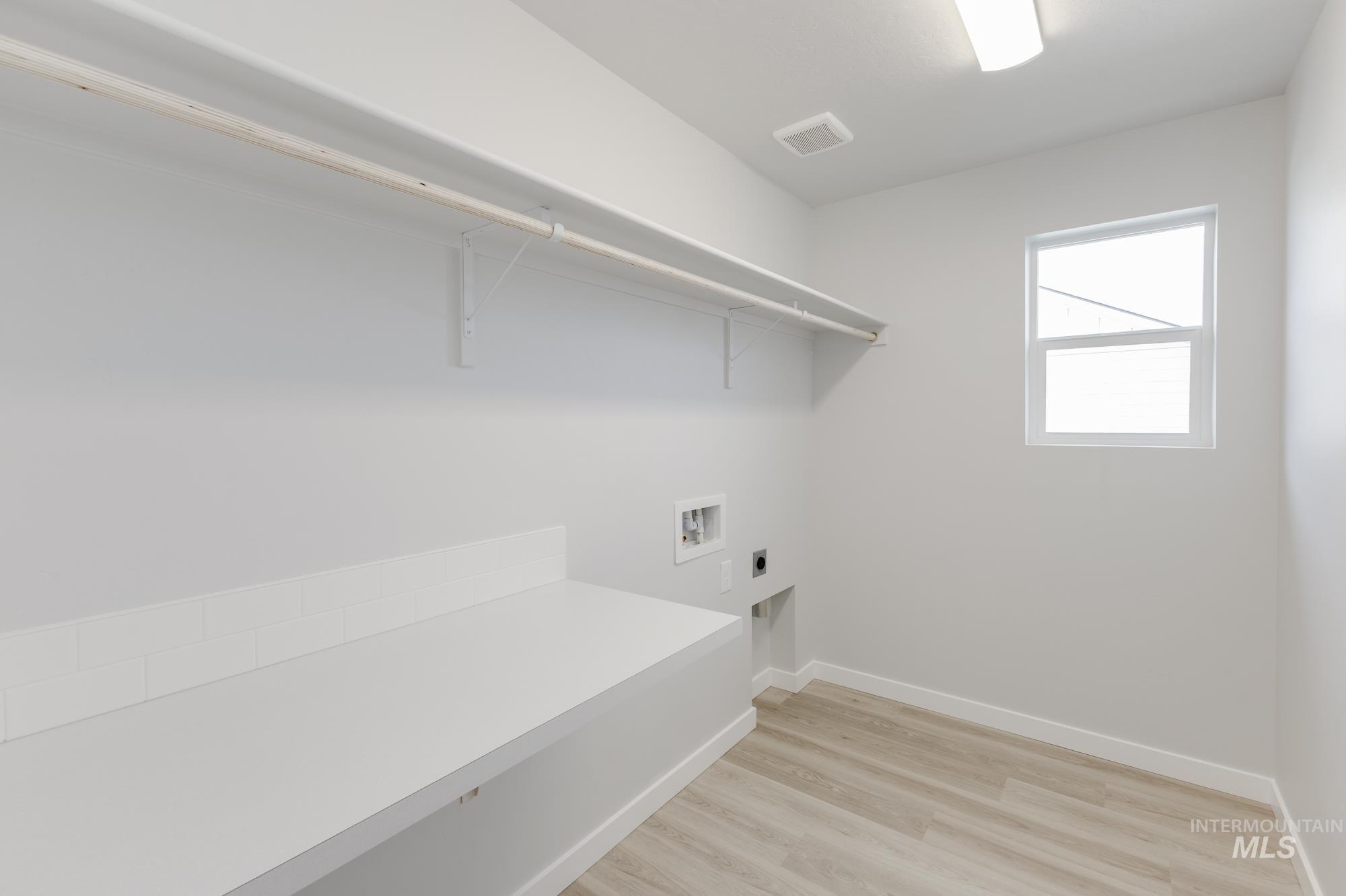 Laundry area featuring electric dryer hookup, light wood finished floors, and washer hookup