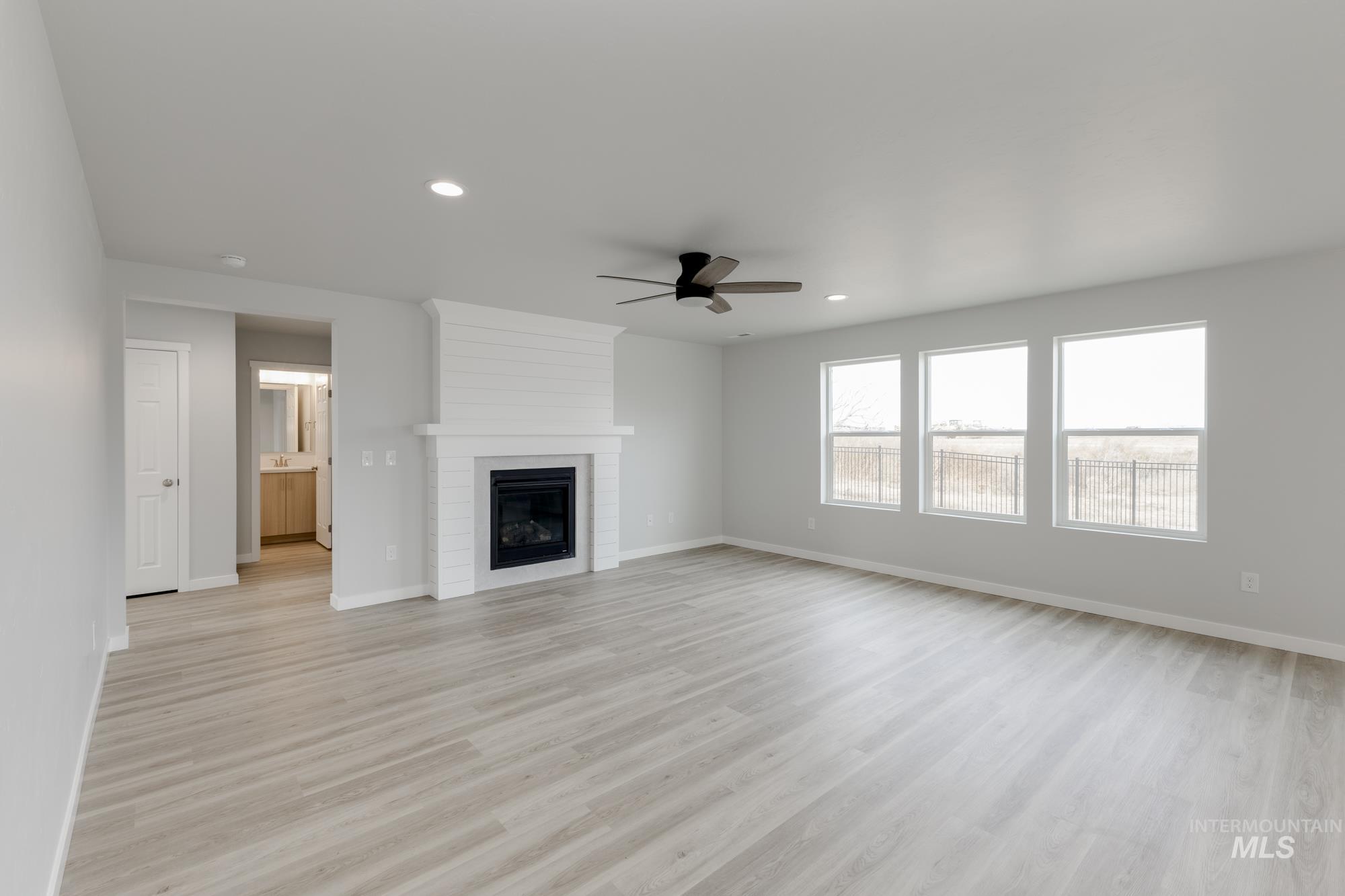 Unfurnished living room featuring recessed lighting, a fireplace, light wood-type flooring, and ceiling fan