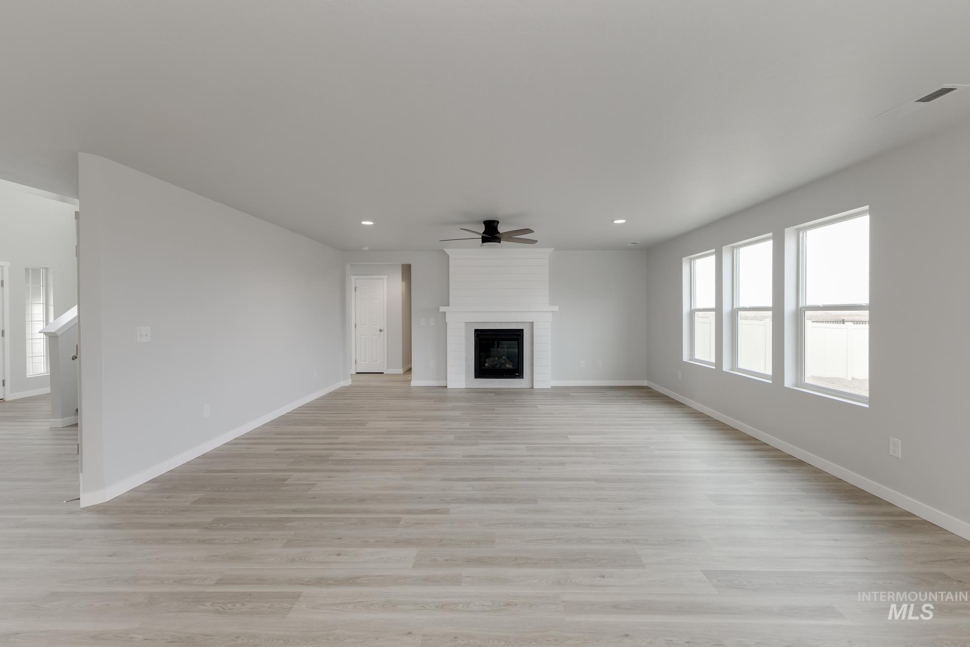 Unfurnished living room with a fireplace, light wood-style flooring, a ceiling fan, and recessed lighting