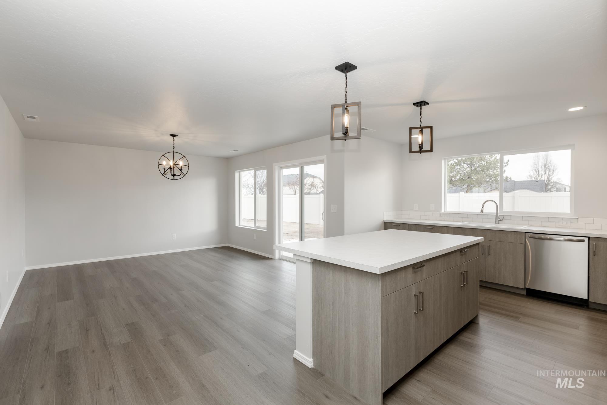 Kitchen with pendant lighting, dishwasher, a kitchen island, and light wood-type flooring