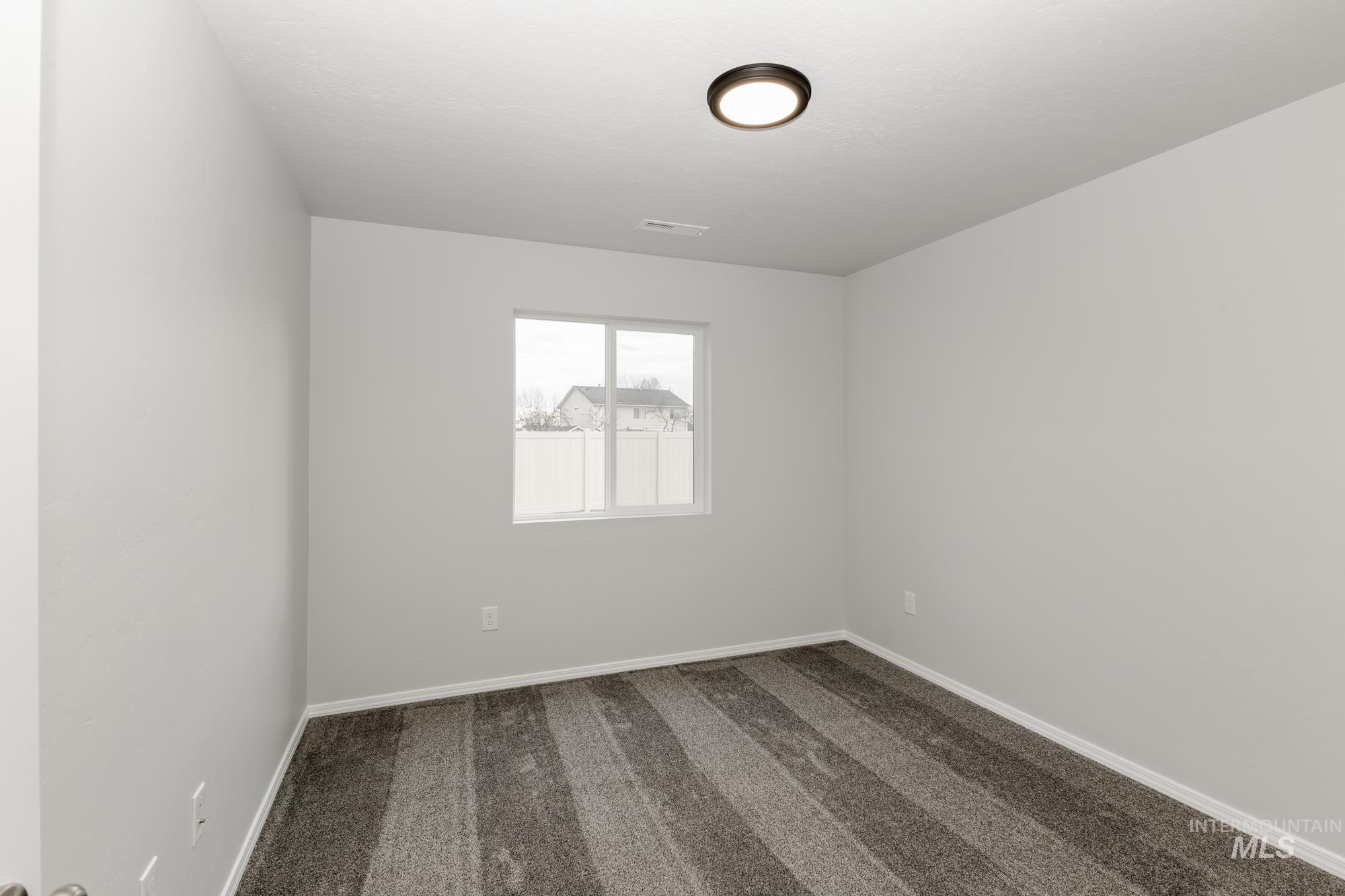 Empty room with carpet flooring and baseboards
