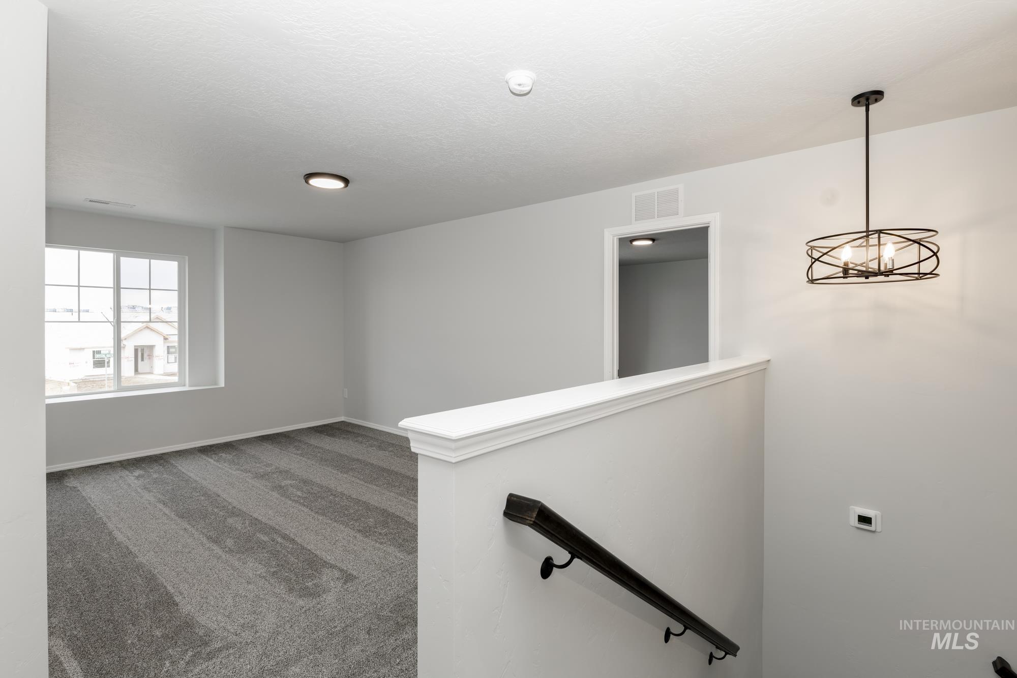 Spare room with carpet and a chandelier