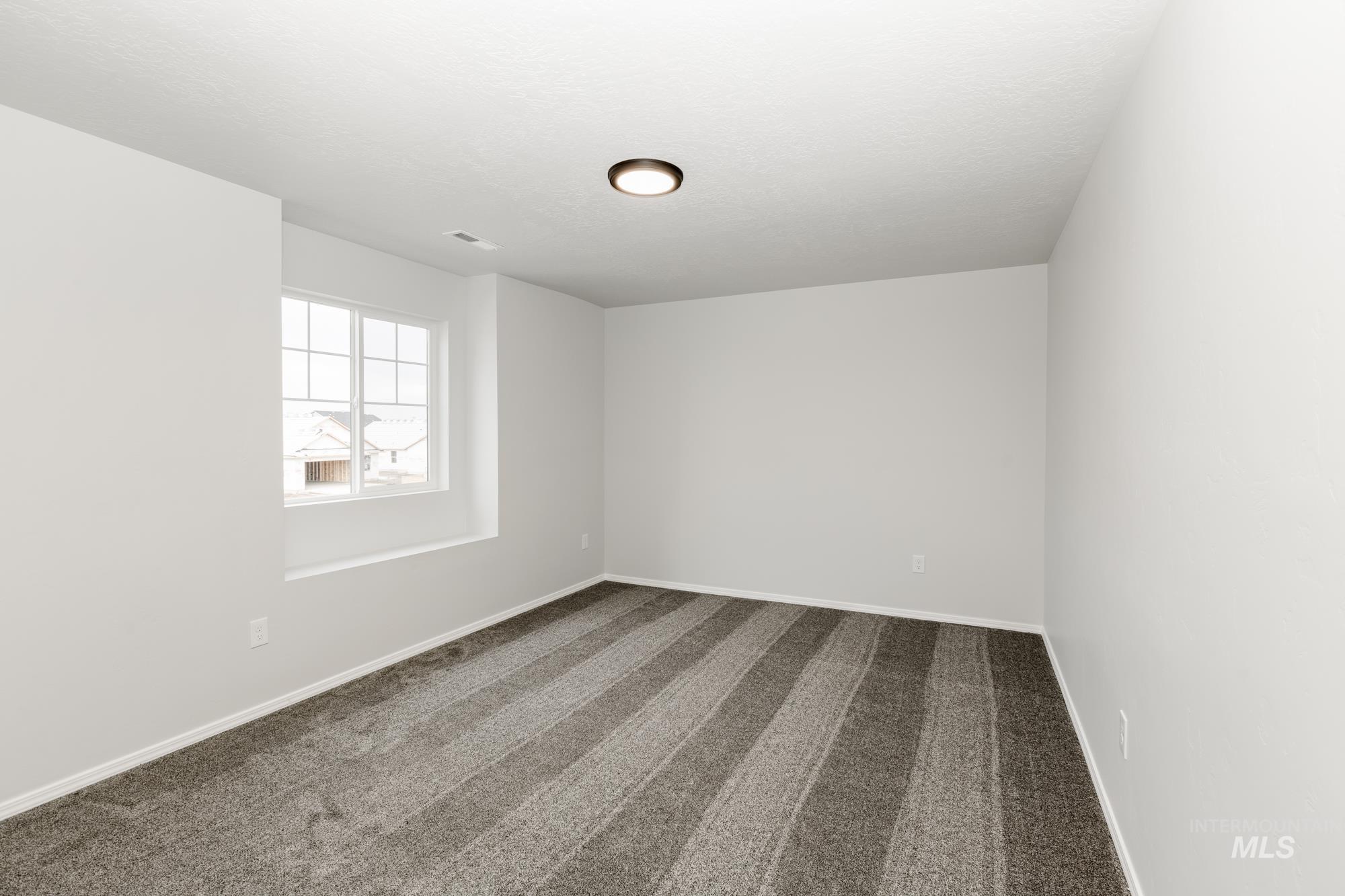 Spare room with carpet and baseboards