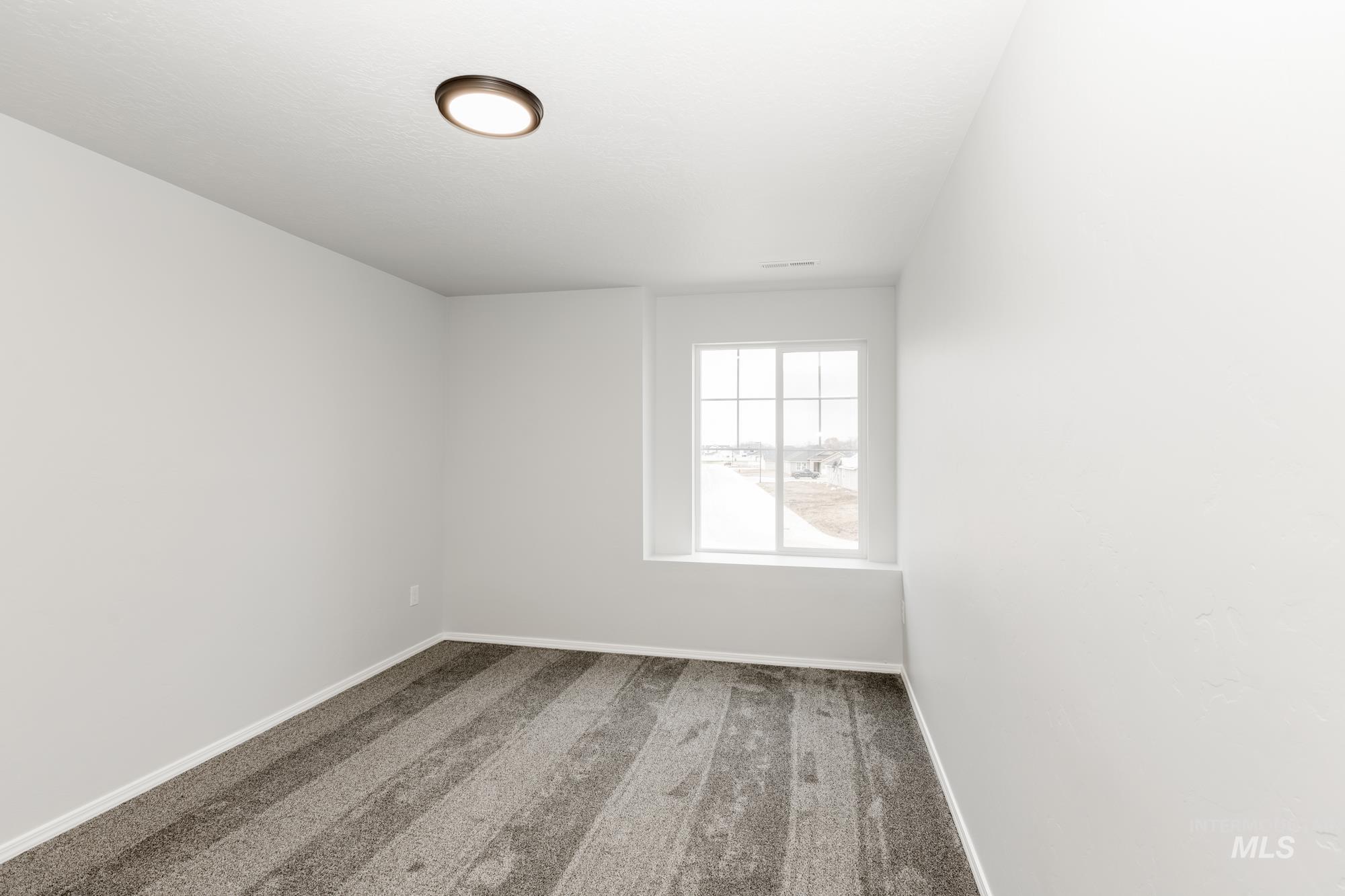 Carpeted empty room with baseboards