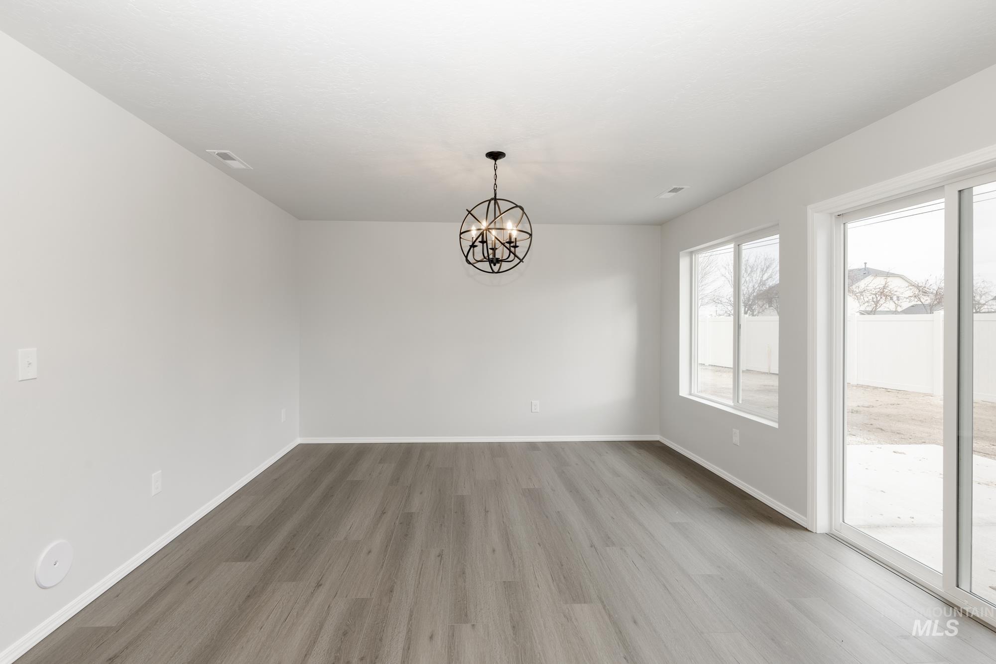 Unfurnished dining area featuring a chandelier and light wood finished floors