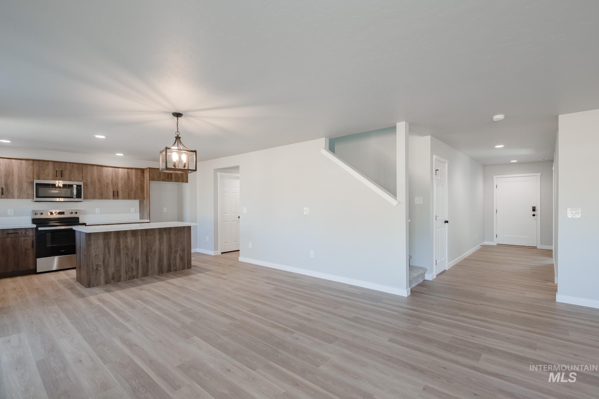 Kitchen with a center island, light countertops, stainless steel appliances, recessed lighting, and light wood finished floors