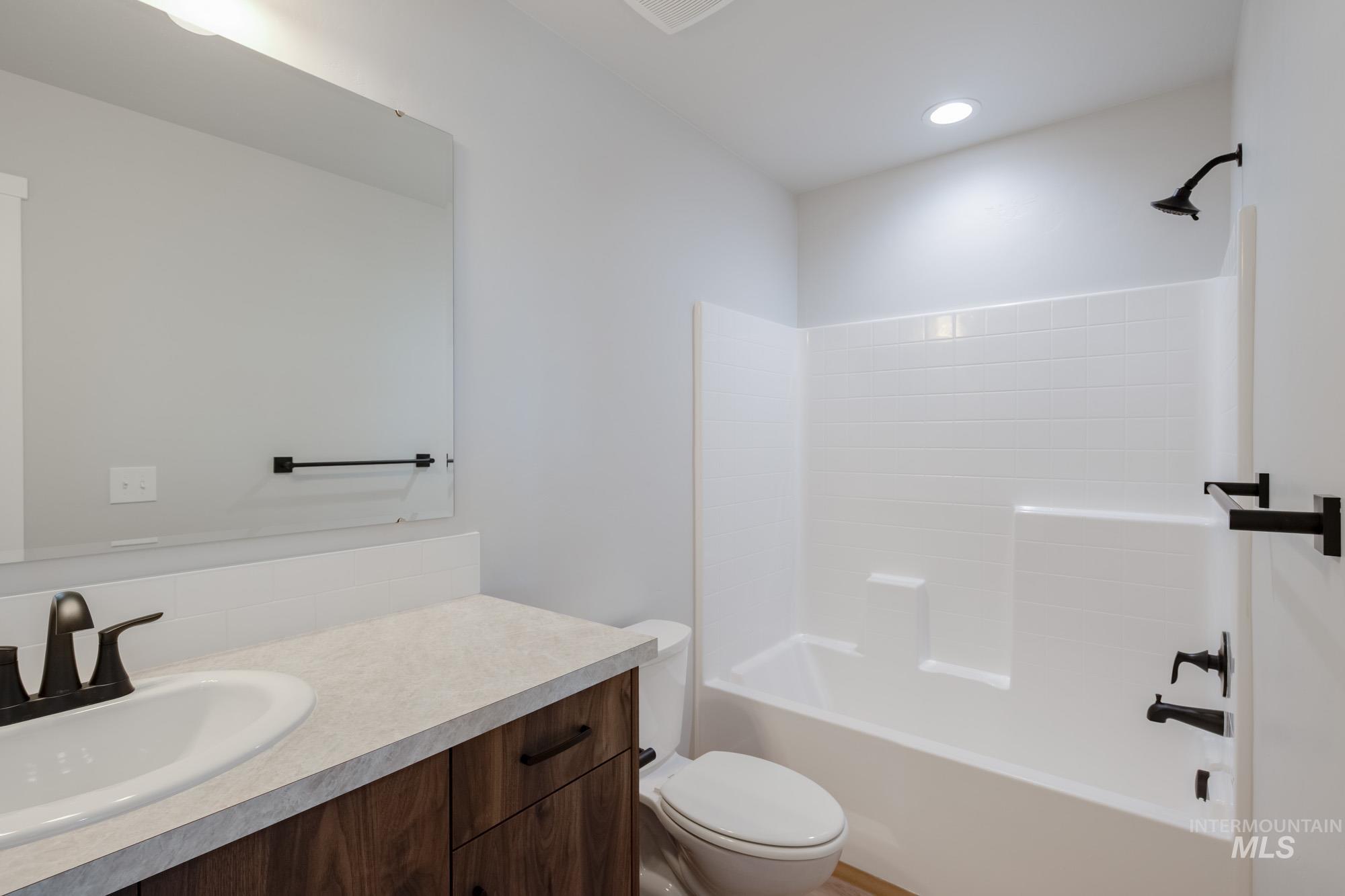 Full bath featuring bathtub / shower combination, vanity, and recessed lighting