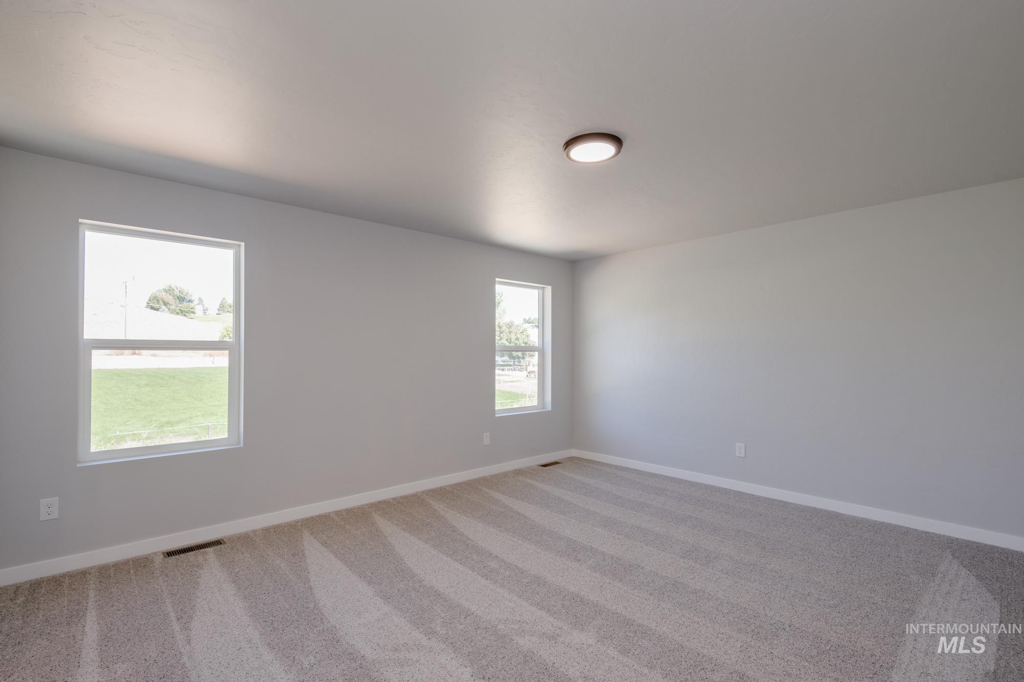Carpeted empty room with baseboards