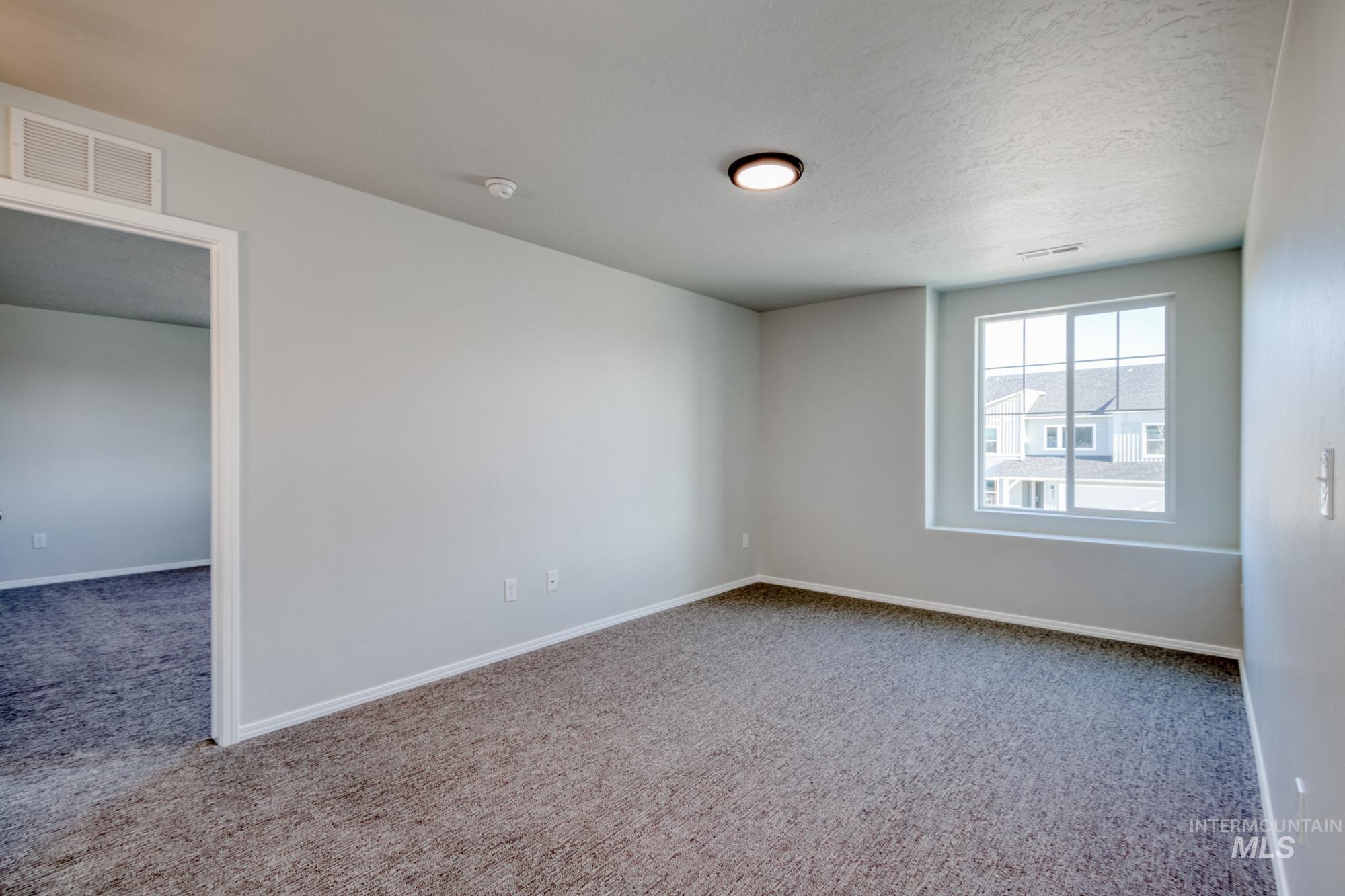 Spare room with carpet floors and a textured ceiling