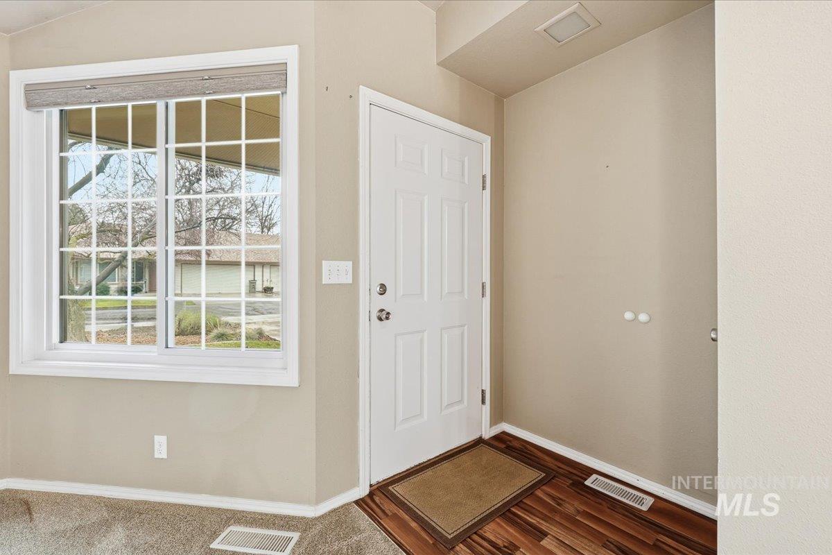 Foyer entrance with baseboards and dark wood-type flooring