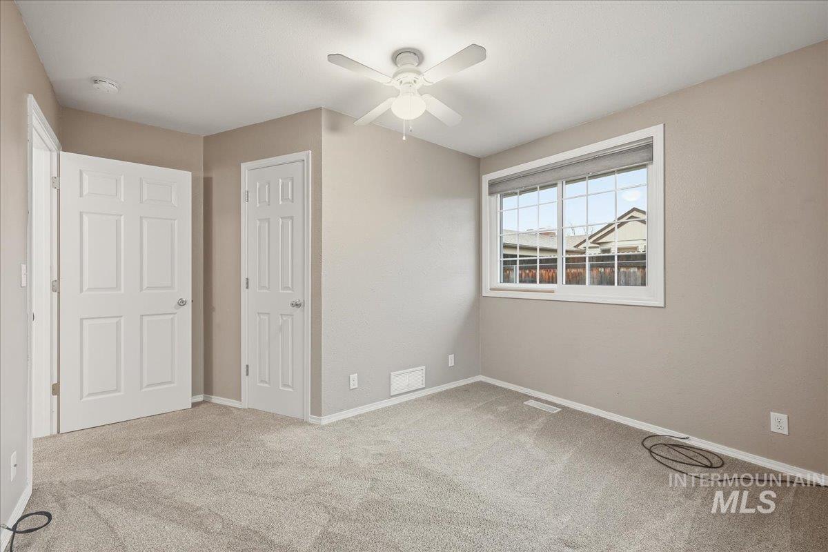 Unfurnished bedroom featuring light carpet, a closet, and a ceiling fan