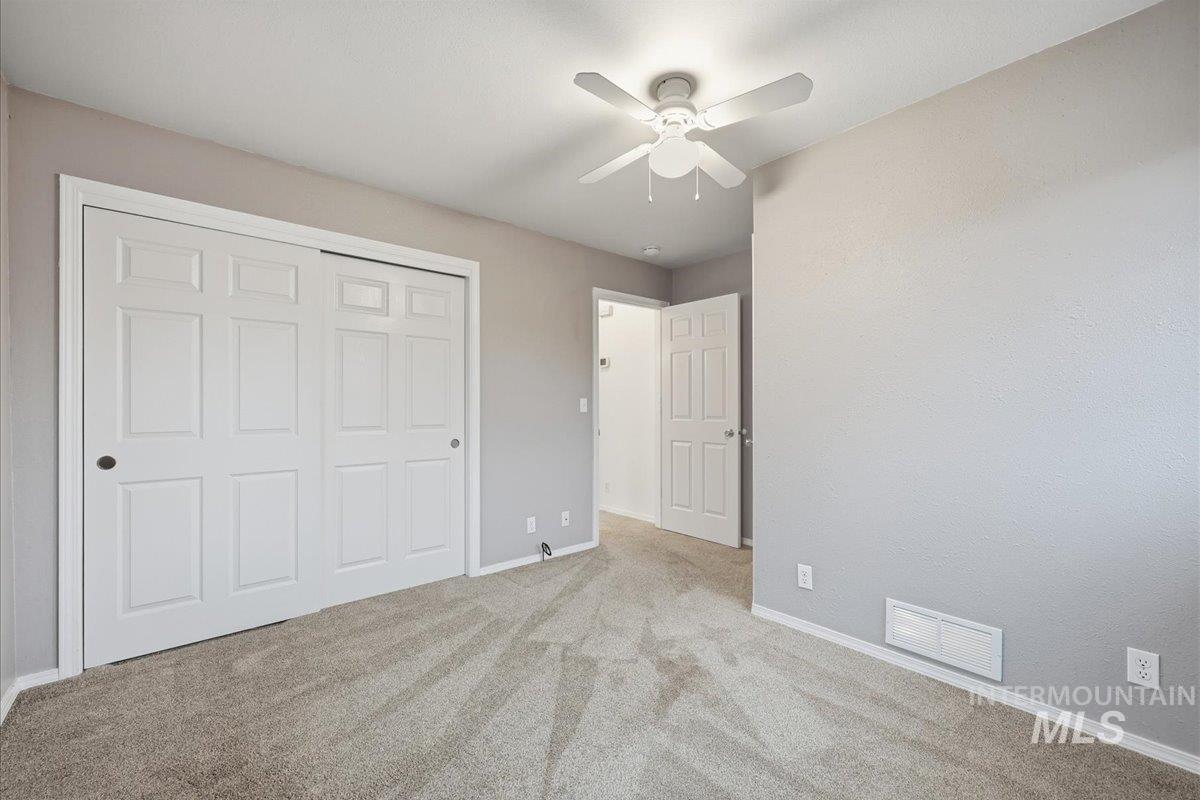 Unfurnished bedroom with carpet floors, a closet, and ceiling fan
