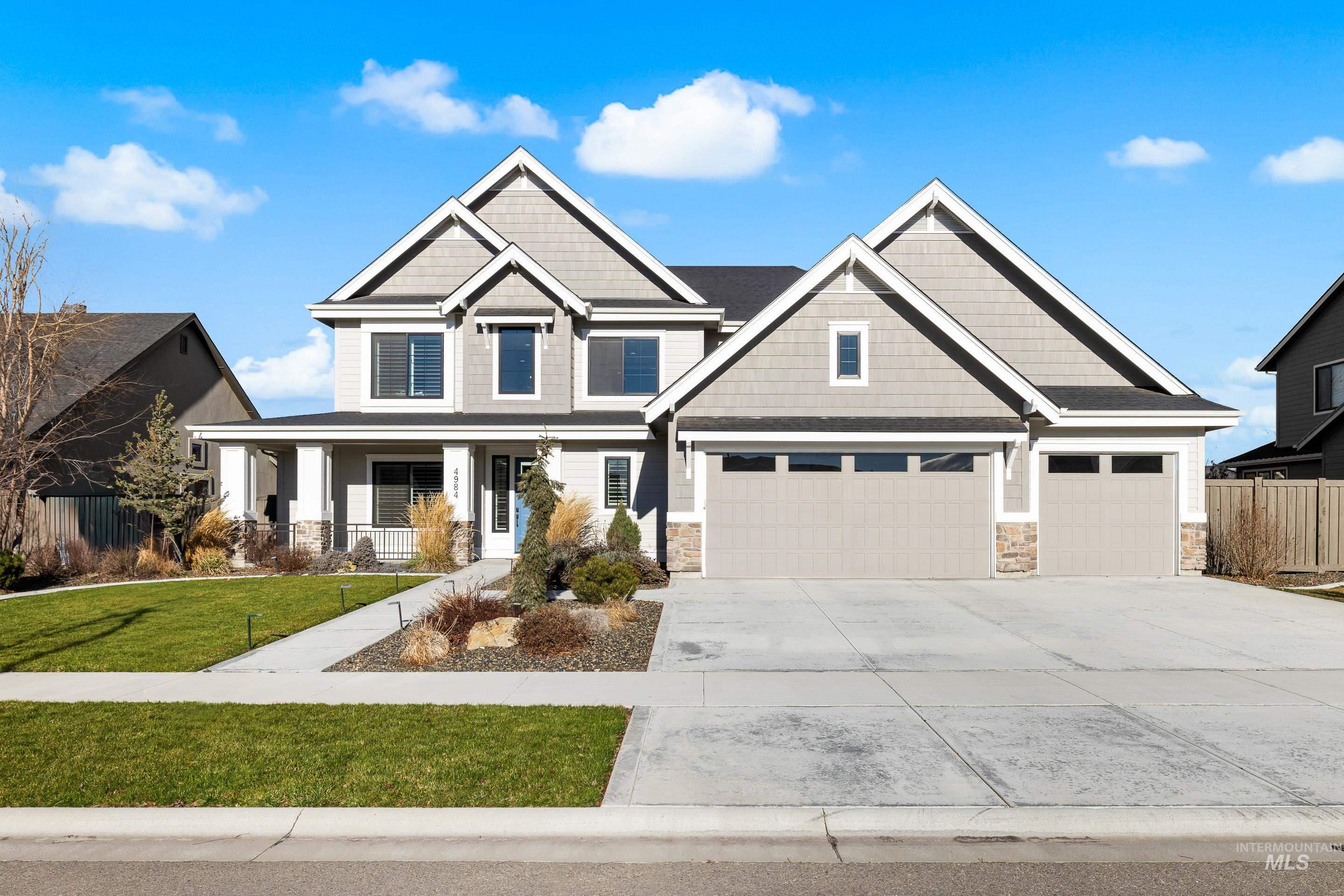 Craftsman house featuring stone siding, a porch, driveway, and a garage