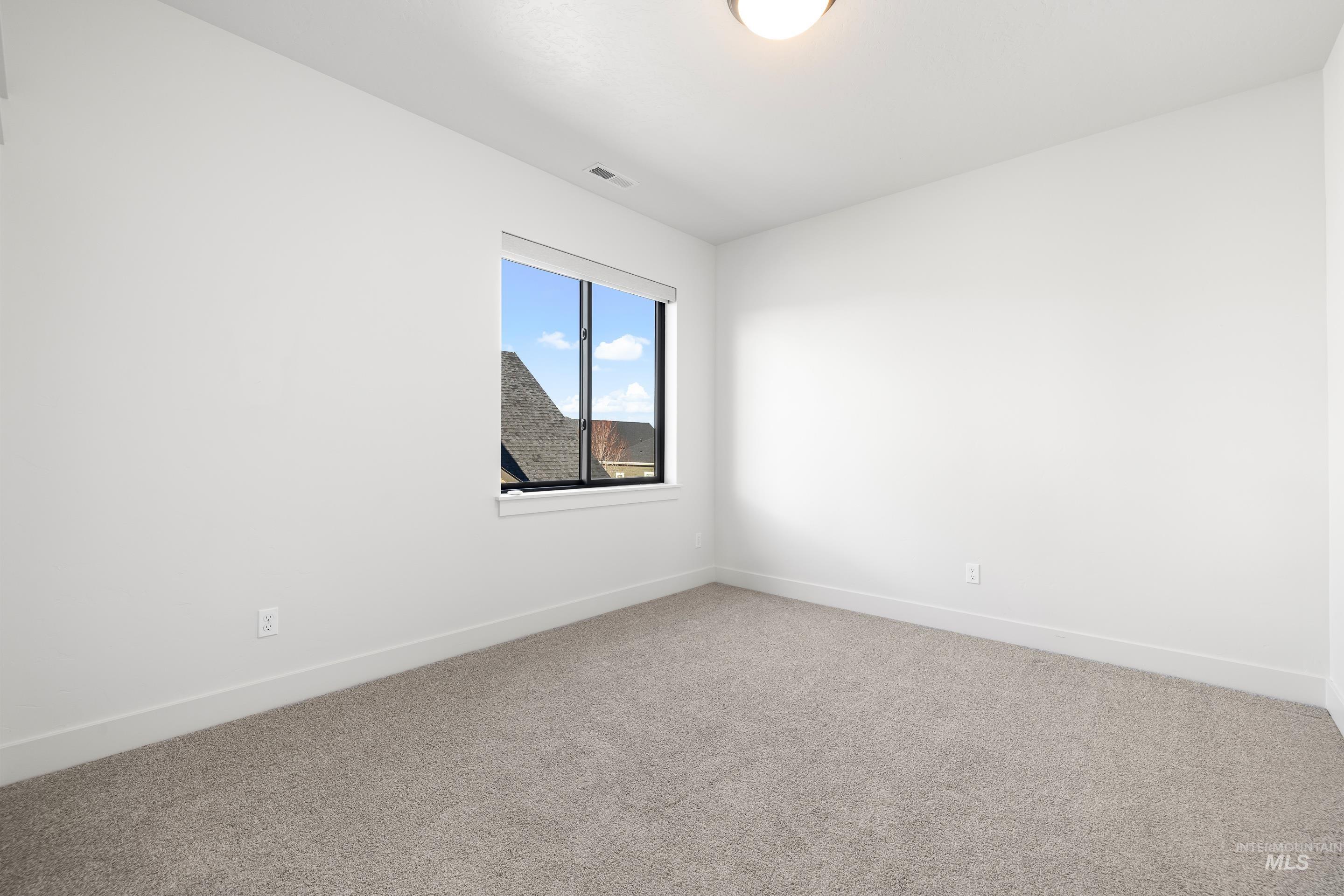 Carpeted empty room with baseboards