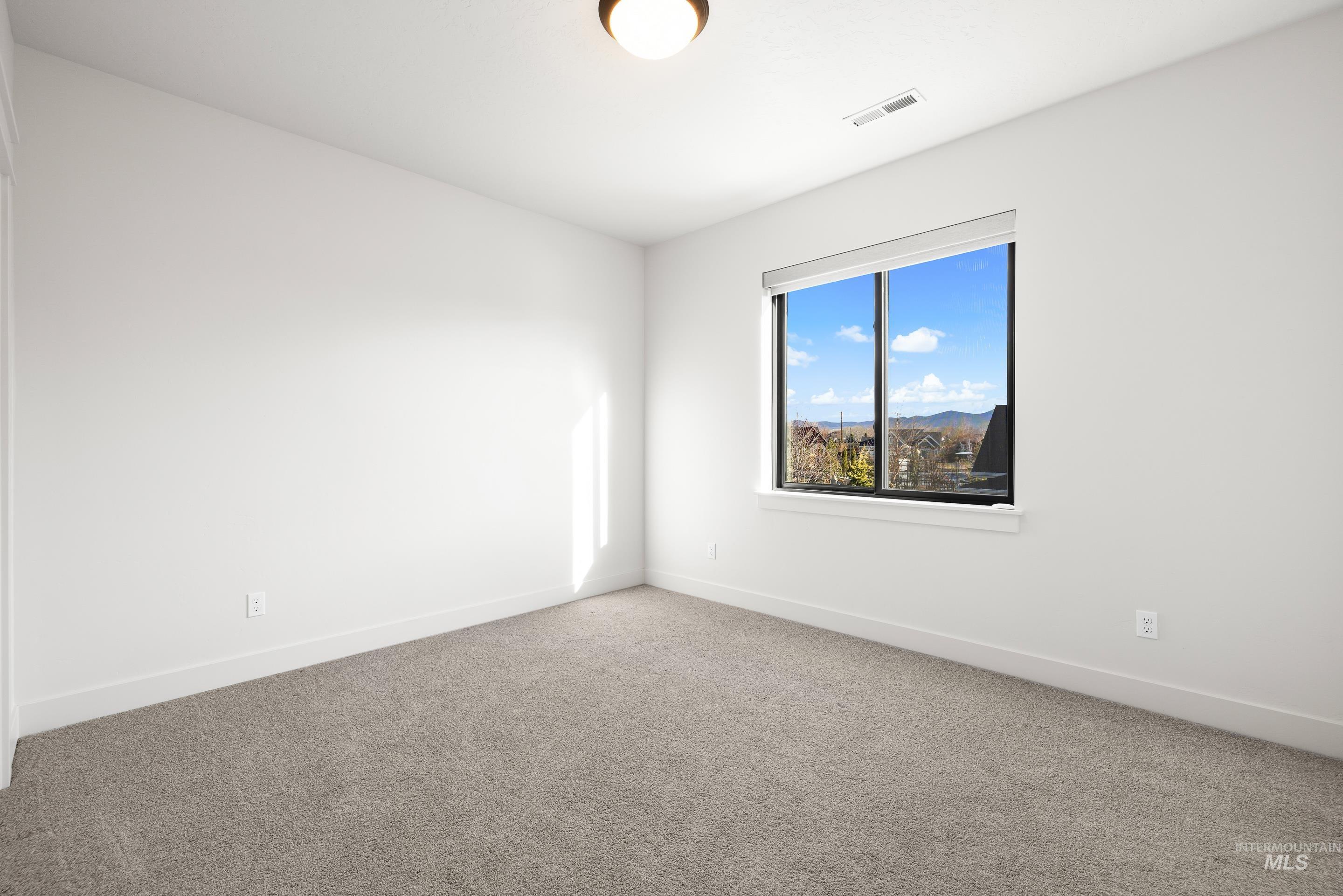 Empty room with carpet flooring and baseboards