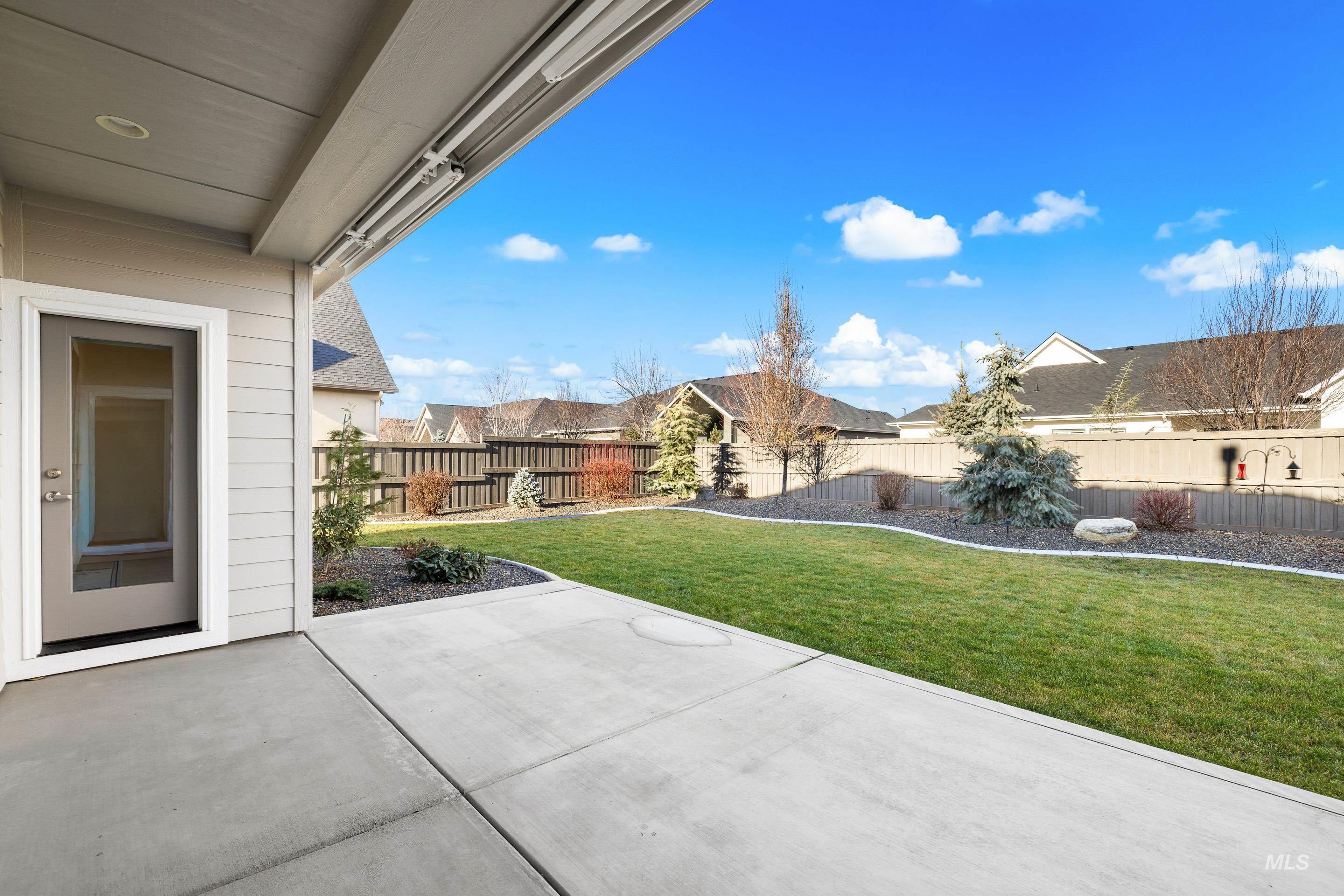 Fenced backyard with a patio area and a residential view