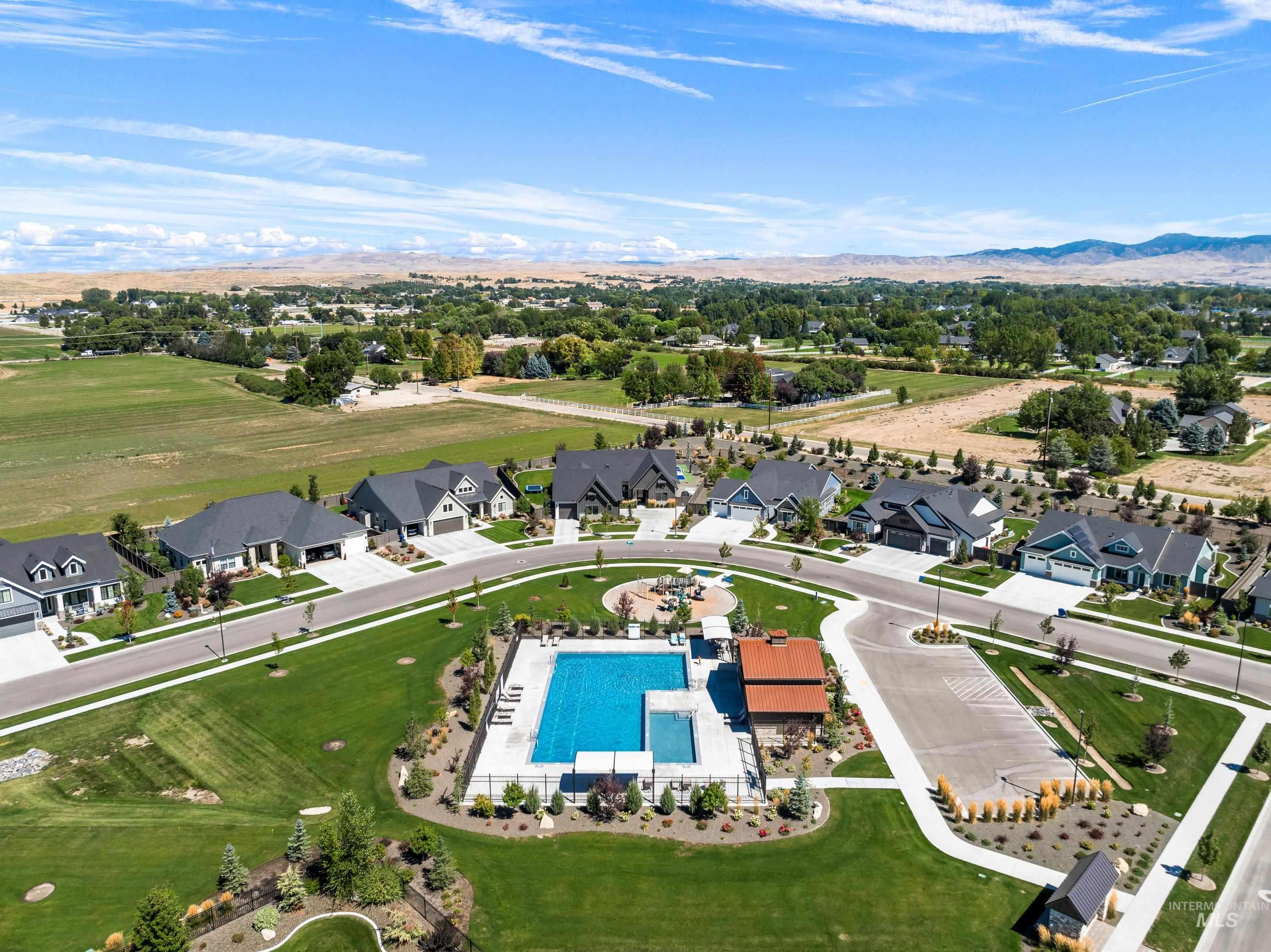 Aerial perspective of suburban area featuring a pool area and a mountainous background