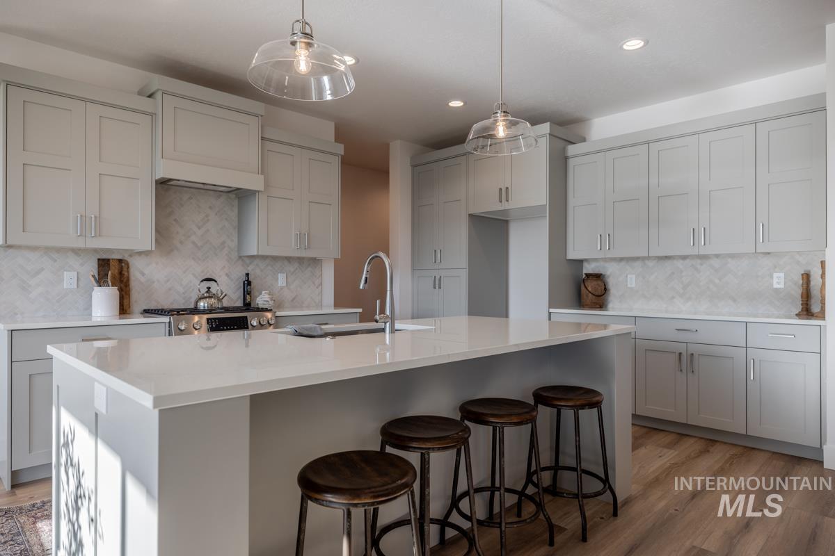 Kitchen with gray cabinetry, tasteful backsplash, pendant lighting, and recessed lighting