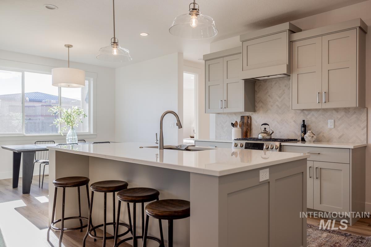 Kitchen featuring decorative light fixtures, light wood finished floors, gray cabinetry, and recessed lighting