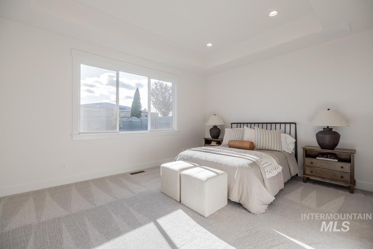 Bedroom featuring a tray ceiling, carpet floors, and recessed lighting