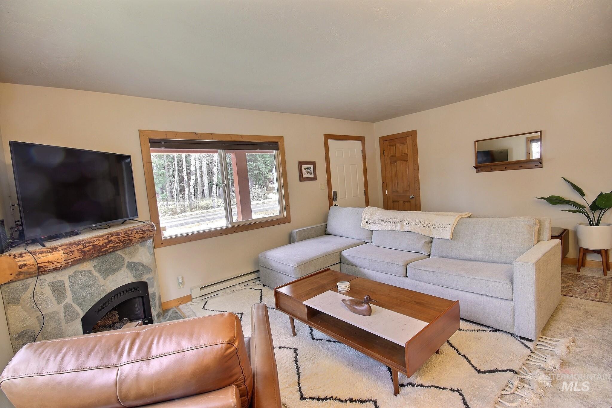 Living room with a baseboard radiator and a fireplace