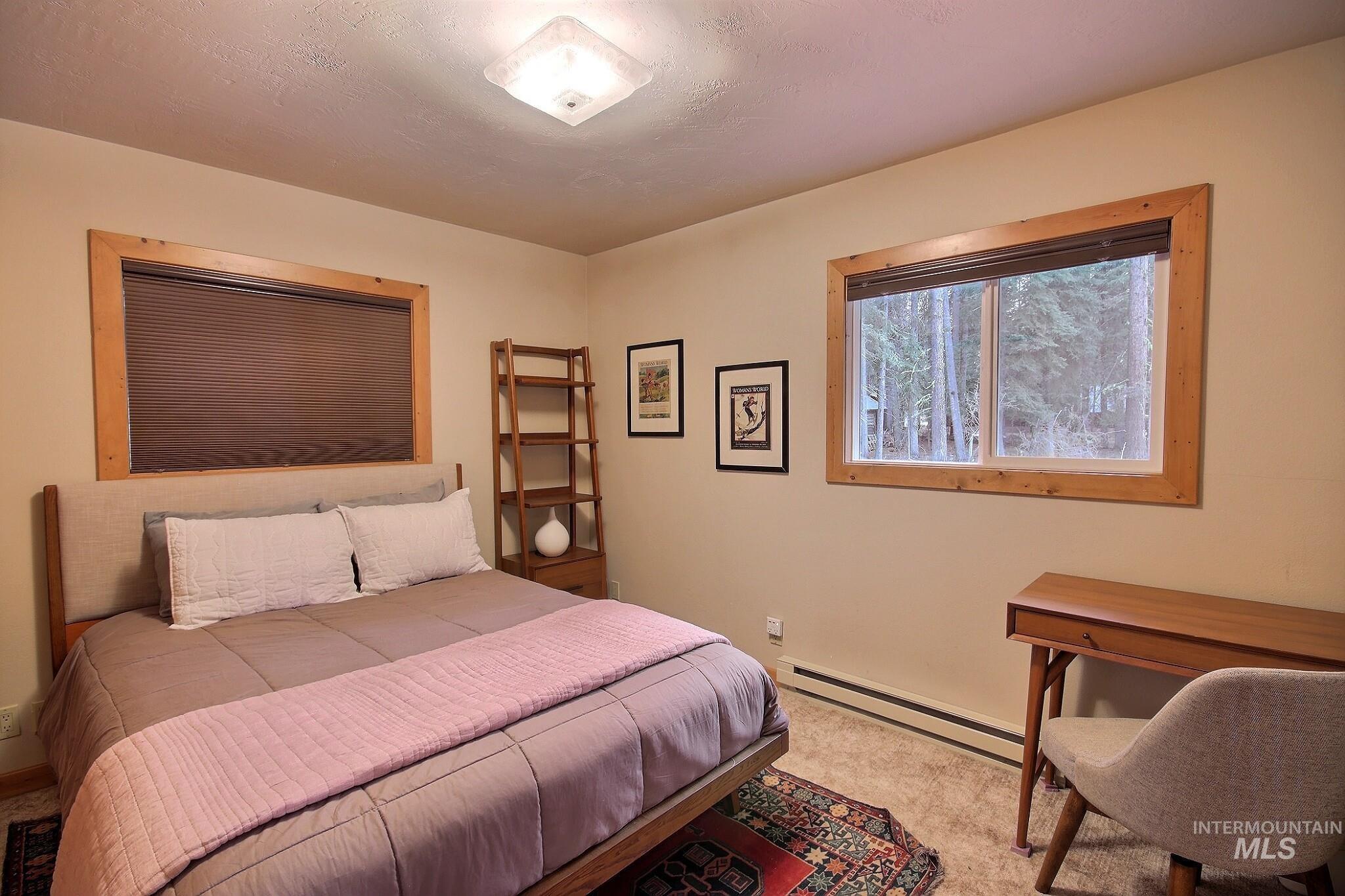 Bedroom featuring a baseboard radiator and carpet floors