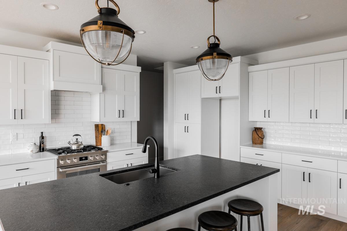Kitchen featuring tasteful backsplash, white cabinetry, and recessed lighting